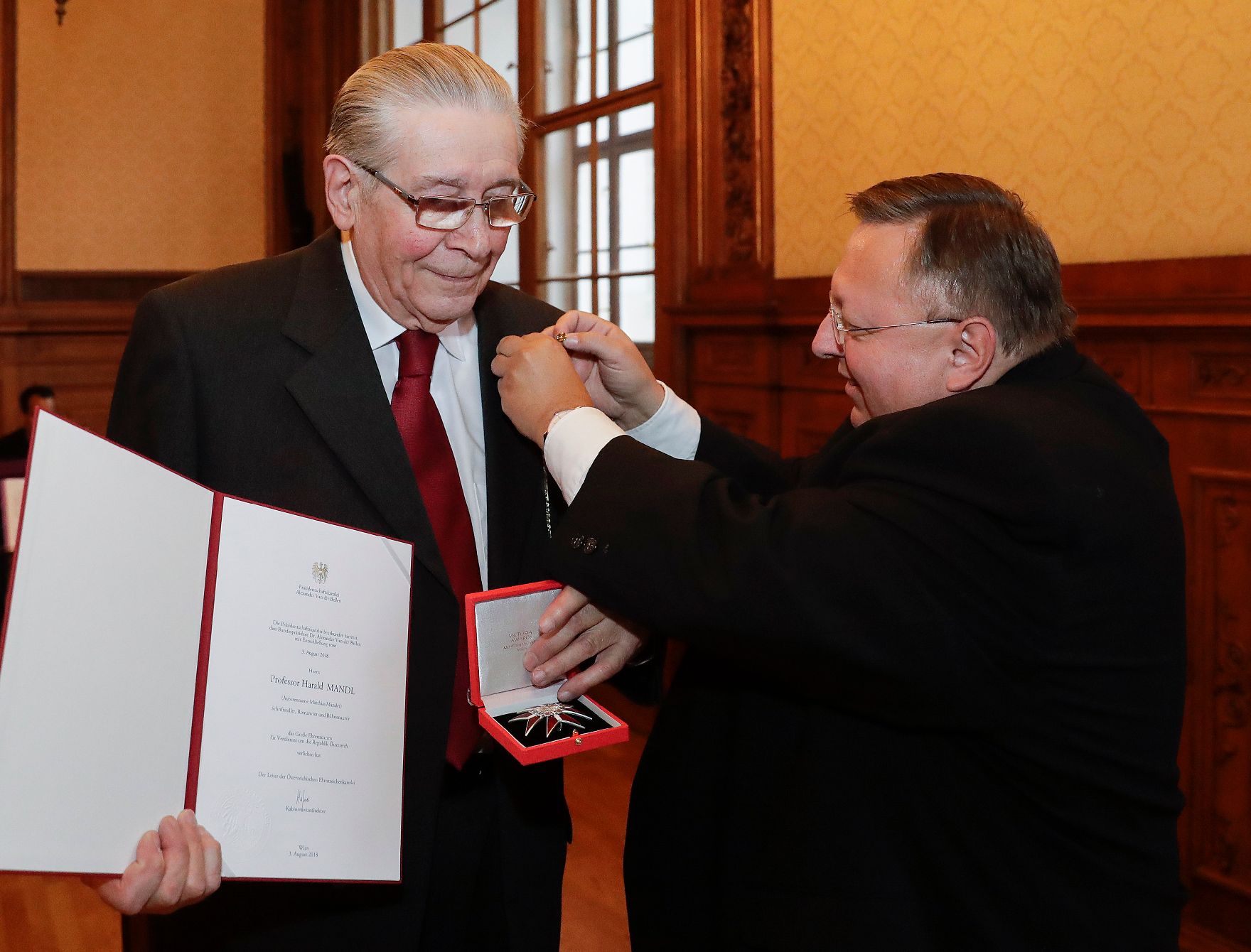 Am 26. November 2018 wurde das Große Ehrenzeichen für Verdienste um die Republik Österreich an Harald Mandl (l.) (Autorenname Matthias Mander) verliehen. Im Bild mit Reinhold Hohengartner (r.).
