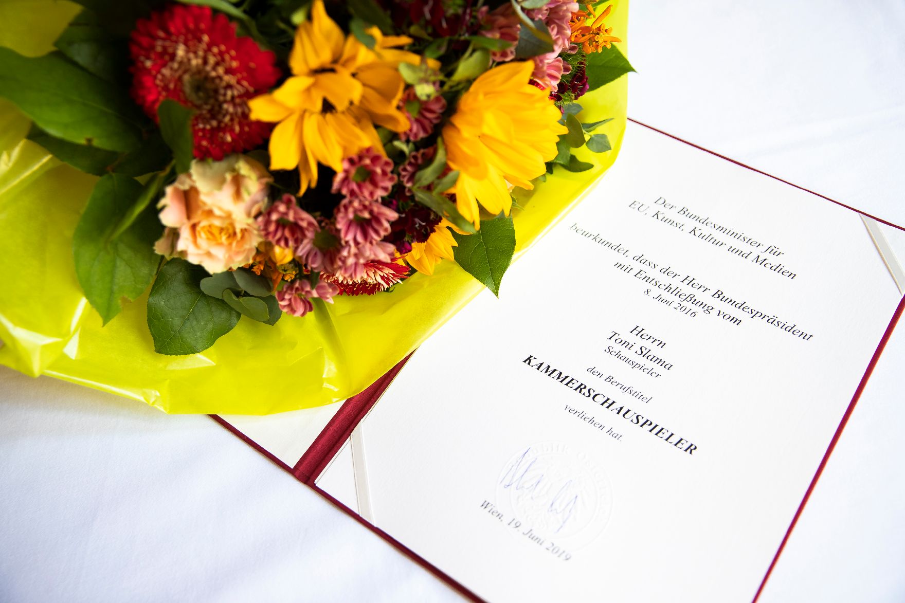 Am 19. Juni 2019 überreichte Christian Kircher die Urkunde, mit der Toni Slama der Berufstitel Kammerschauspieler verliehen wurde.