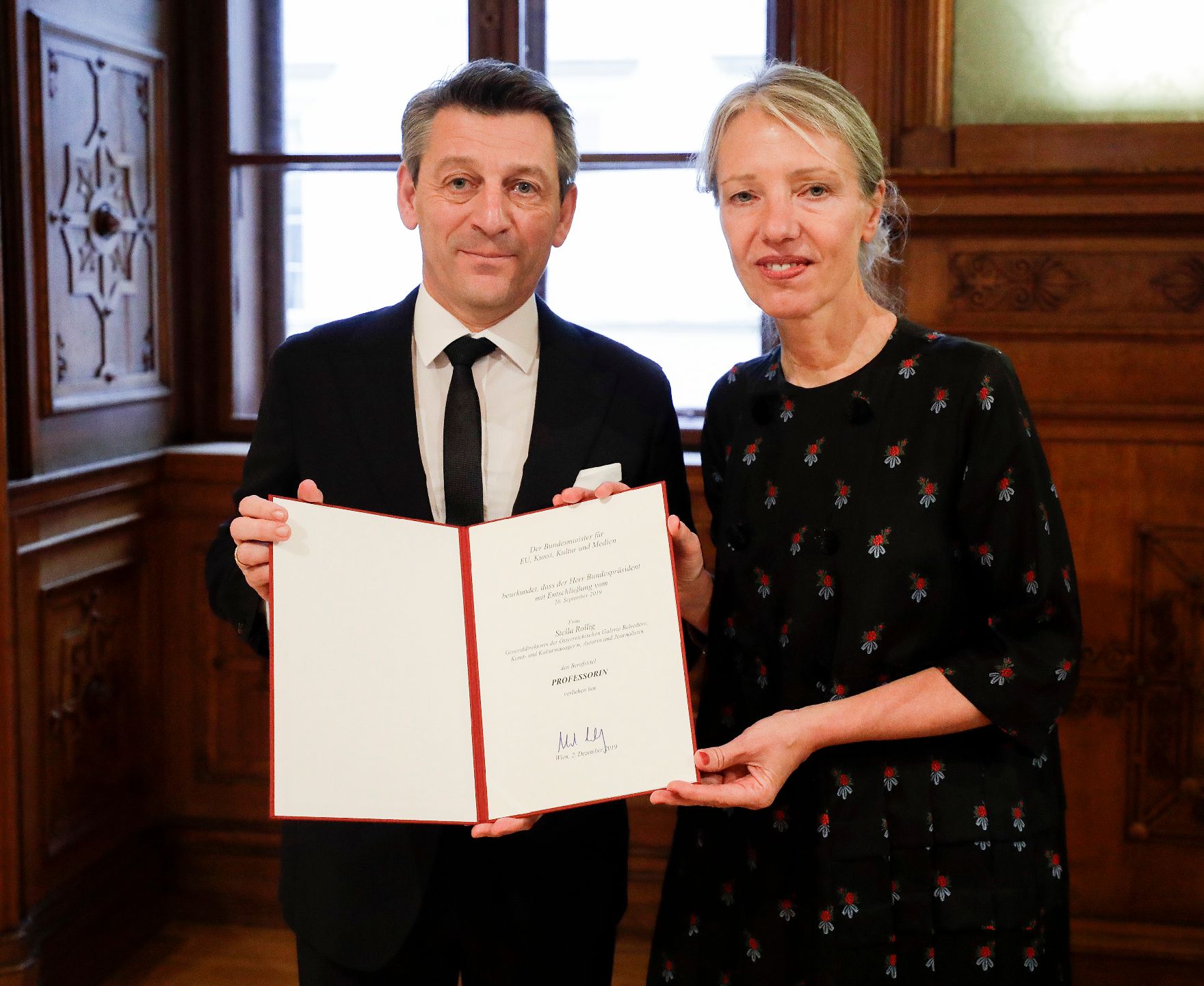 Am 2. Dezember 2019 überreichte Sektionschef Jürgen Meindl (l.) die Urkunde über die Verleihung des Berufstitels Professorin an Stella Rollig (r.).