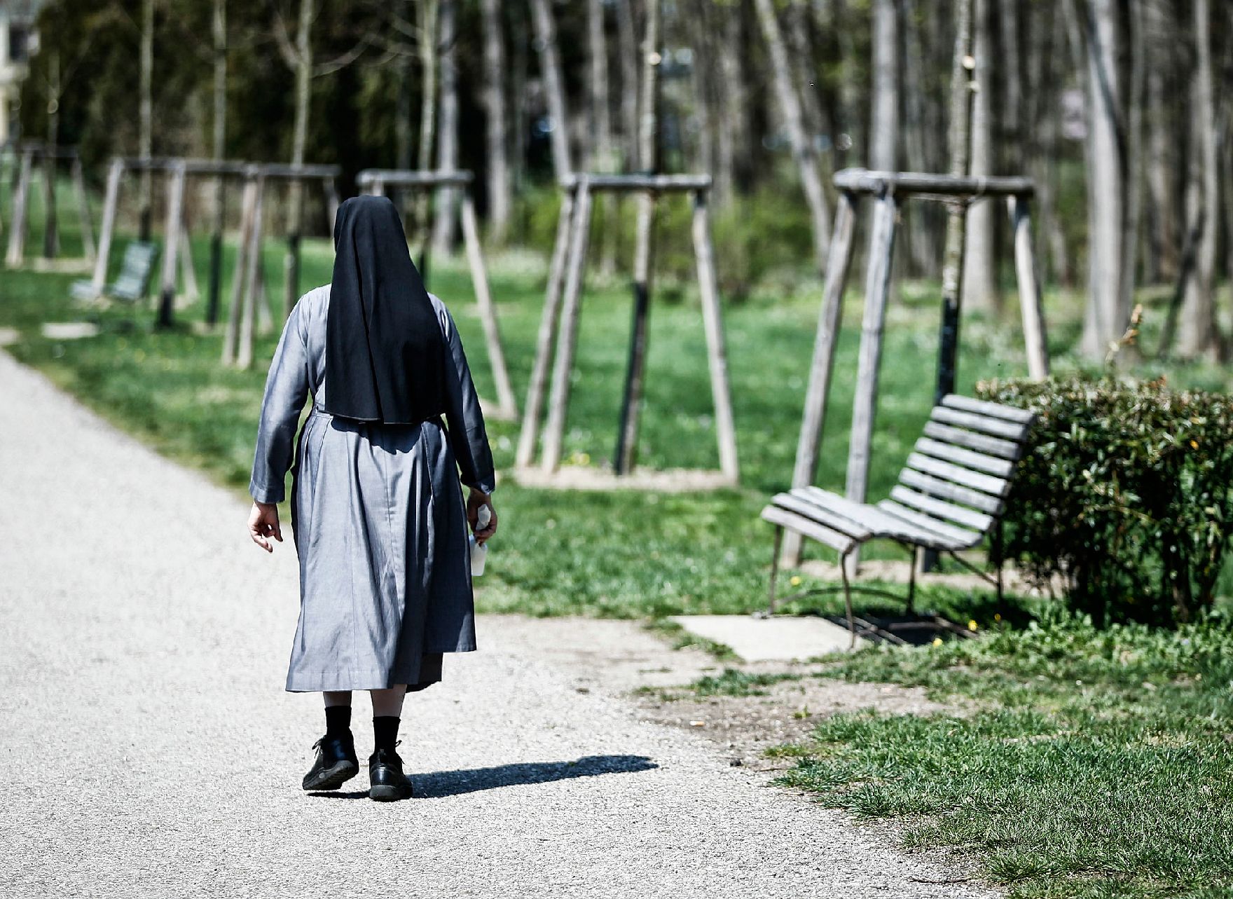 Eine Nonne im Park von Laxenburg. Schlagworte: Bäume, Frühling, Mensch, Natur, Park, Parkbank, Pflanzen