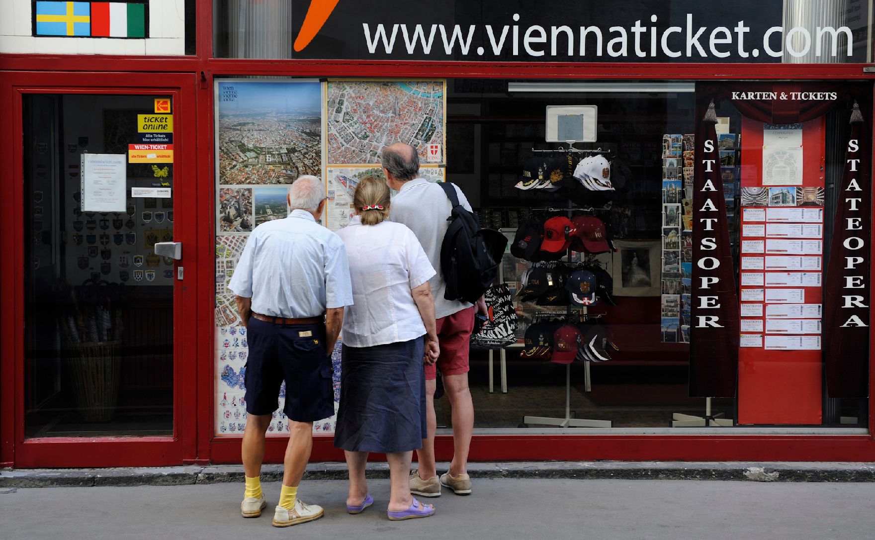 Touristen studieren den Stadtplan in der Auslage eines "Viennaticket'"-Shops. Schlagworte: Frau, Gebäude, Mann, Menschen, Rucksack, Stadtleben