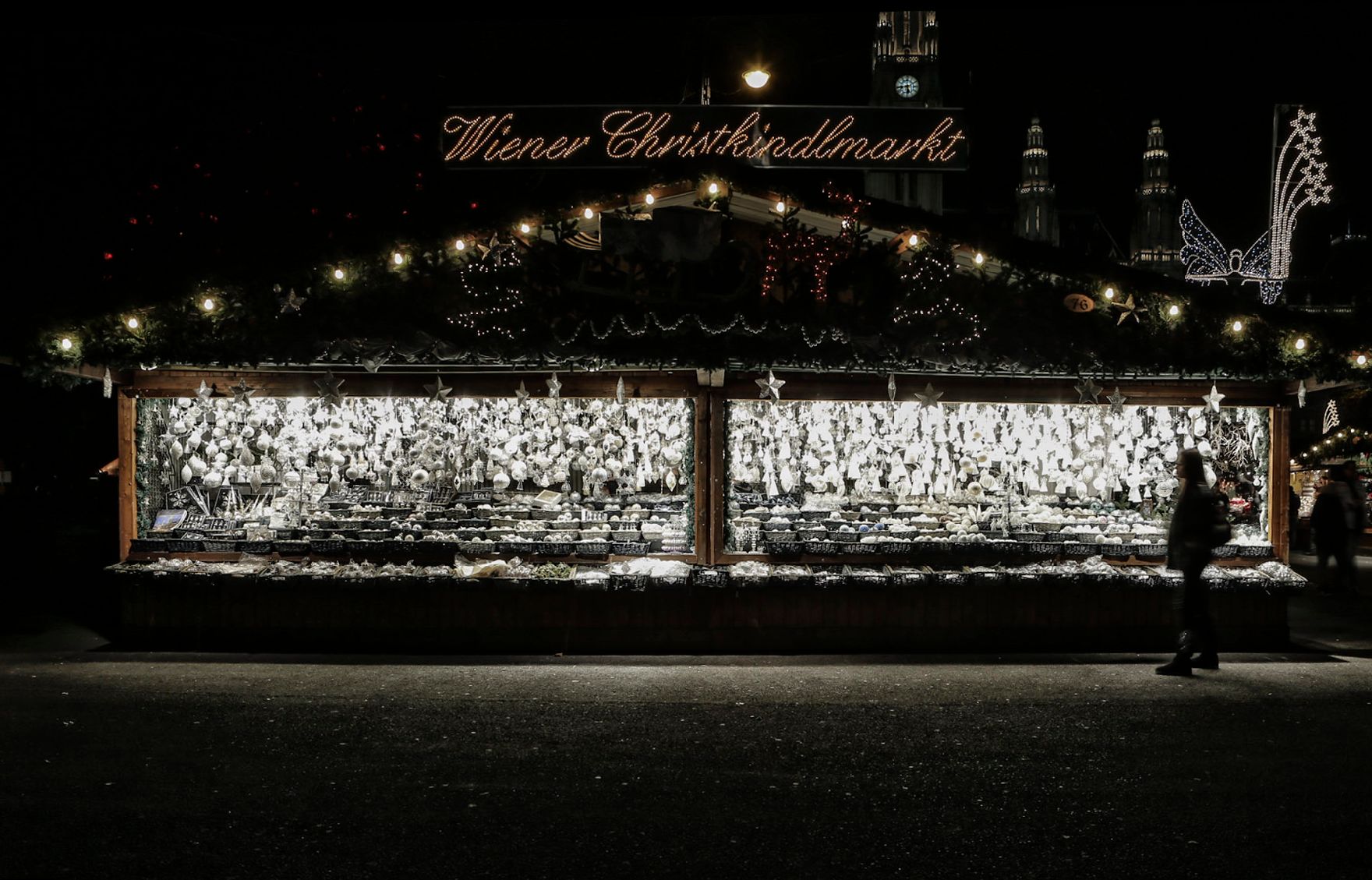 Der Christkindlmarkt am Rathausplatz bei Nacht. Schlagworte: Abend, Beleuchtung, Kugeln, Marktstand, Mensch, Sehenswürdigkeit, Stadtlandschaften, Weihnachten