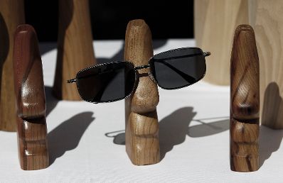 Holzfiguren die als Brillenhalter dienen. Schlagworte: Bauernmarkt, Brille, Markt, Marktstände, Schnitzerei, Sonnenbrille, Wirtschaft