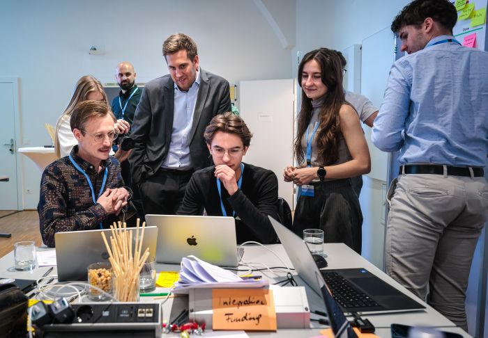 Am 5. Mai 2026 besuche Staatssekret&auml;r Alexander Pr&ouml;ll (3.v.l.) den Public AI Hackathon im Bundeskanzleramt.