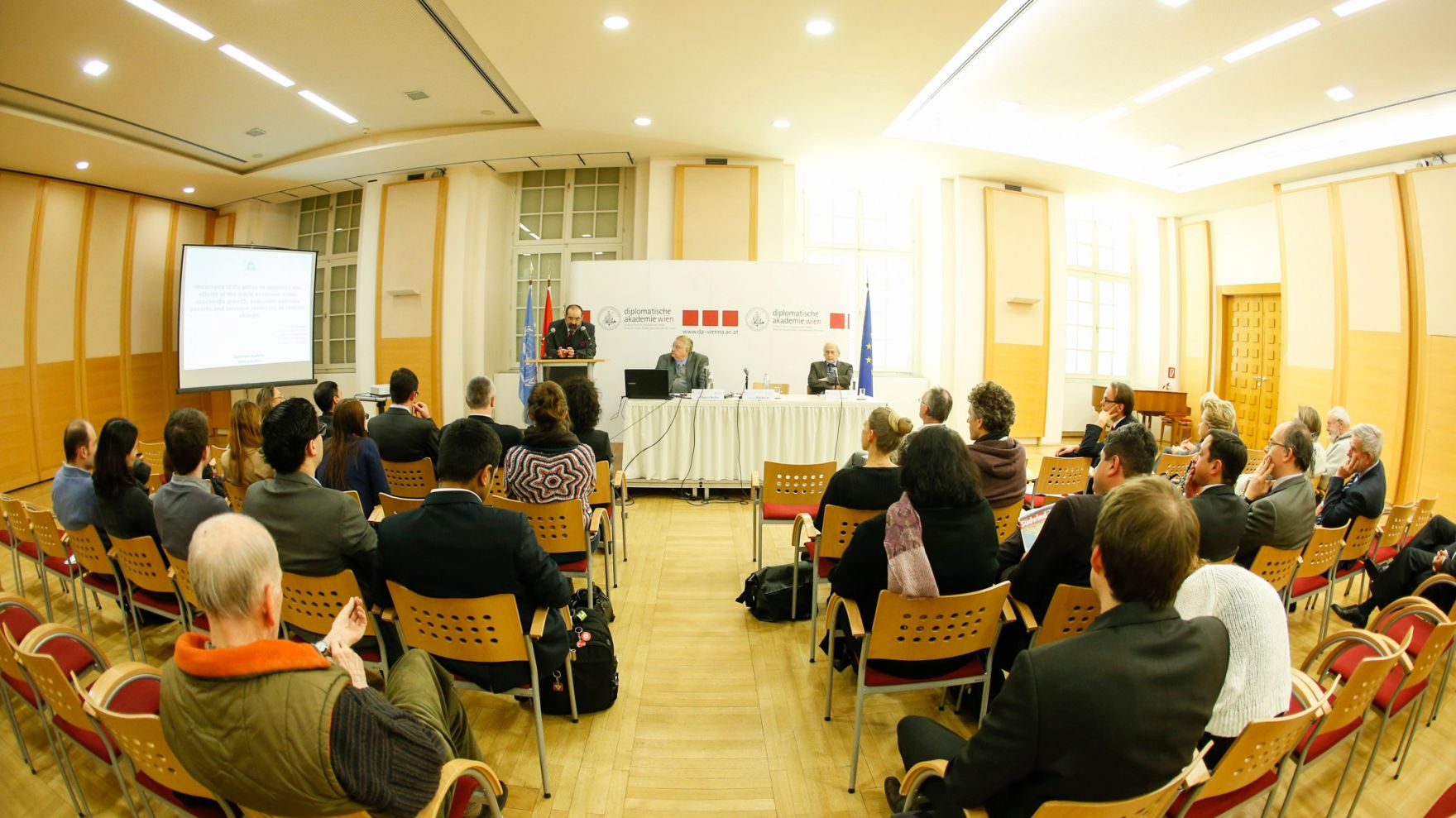 Am 9. Februar 2015 fand in der Diplomatischen Akademie Wien ein Gespr&auml;ch zum Thema: &bdquo;NICARAGUAN STATE POLICY TO MINIMISE THE EFFECTS OF THE WORLD ECOMOMIC CRISIS, ACCELERATE GROWTH, OVERCOME EXTREME POVERTY AND INCREASE RESILIENCE TO CLIMATE CHANGE&ldquo; statt. Blick aus dem Publikum. Am Rednerpult Priv.-Doz. Alexander Balthasar, Leiter des Instituts f&uuml;r Staatsorganisation und Verwaltungsreform im Bundeskanzleramt. Am Podium Dr. Paul Oquist Kelley, Minister im Amt des Pr&auml;sidenten der Republik Nicaragua (l.) und Dr. Peter Stania, Vizepr&auml;sident des Internationalen Instituts f&uuml;r den Frieden (r.).