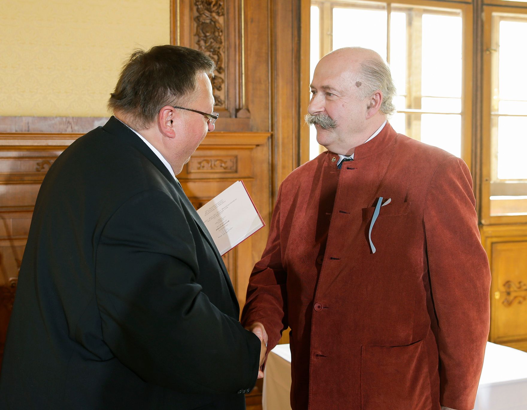 Am 25. April 2016 &uuml;berreichte Ministerialrat Reinhold Hohengartner (l.) die Urkunde, mit der Albrecht Meyer (r.) der Berufstitel Professor verliehen wurde.