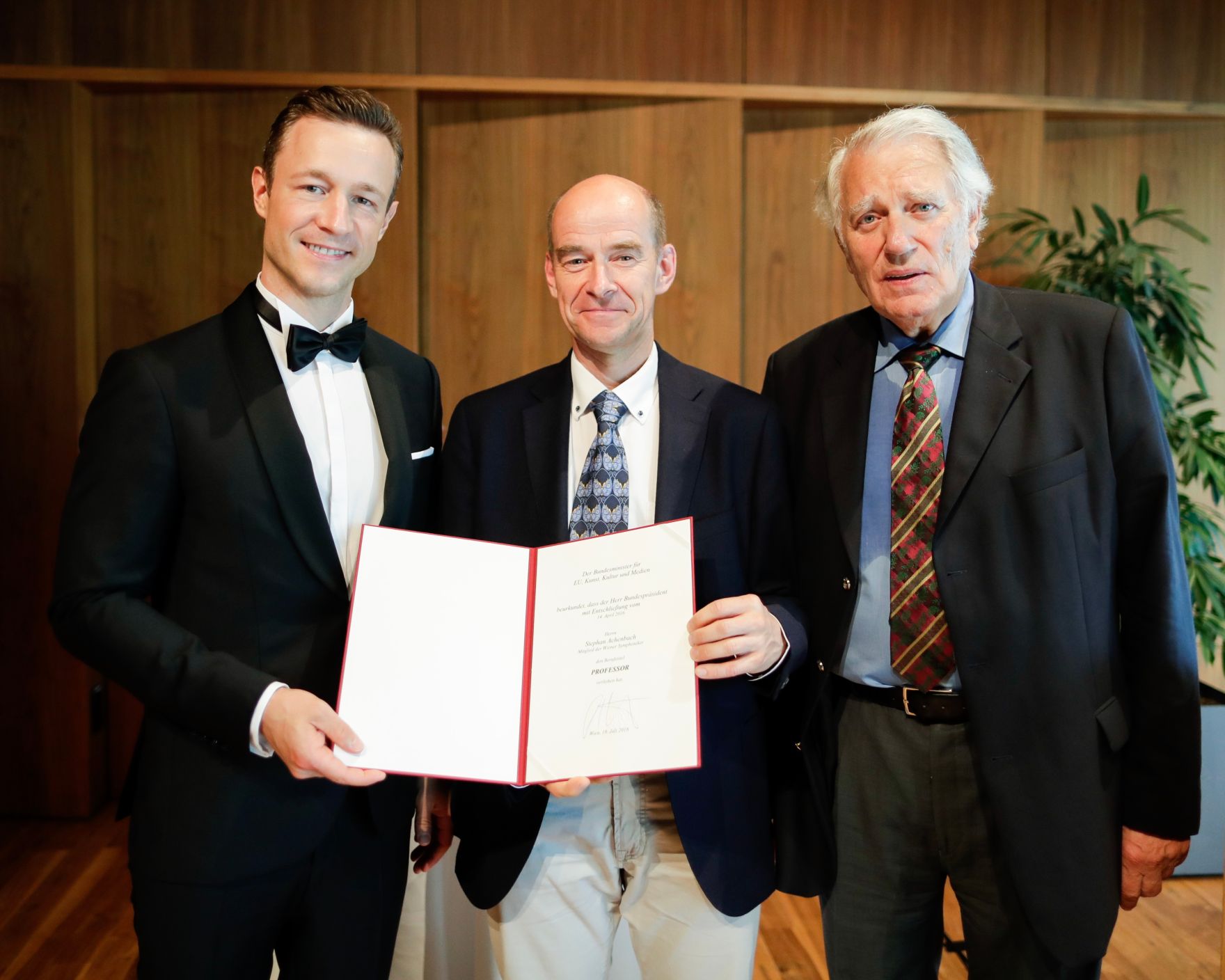 Am 18. Juli 2018 reiste Bundesminister Gernot Bl&uuml;mel (l.) anl&auml;sslich der Er&ouml;ffnung der Bregenzer Festspiele nach Bregenz. Im Bild bei der &Uuml;berreichung der Urkunde des Berufstitels Professor an das Mitglied der Wiener Symphoniker Stephan Achenbach (m.) mit dem Pr&auml;sidenten der Wiener Symphoniker Rudolf Streicher (r.).