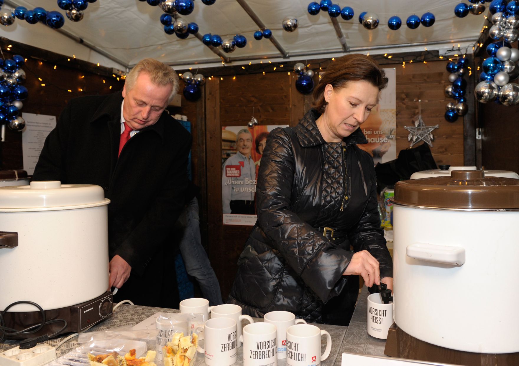 Am 21. Dezember 2012 schenkten Frauenministerin Gabriele Heinisch-Hosek (r.) und Sozialminister Rudolf Hundstorfer (l.) Punsch als Statement gegen &bdquo;Gewalt an Frauen/White Ribbon&ldquo; am Weihnachtsmarkt bei der Freyung, Wien aus.