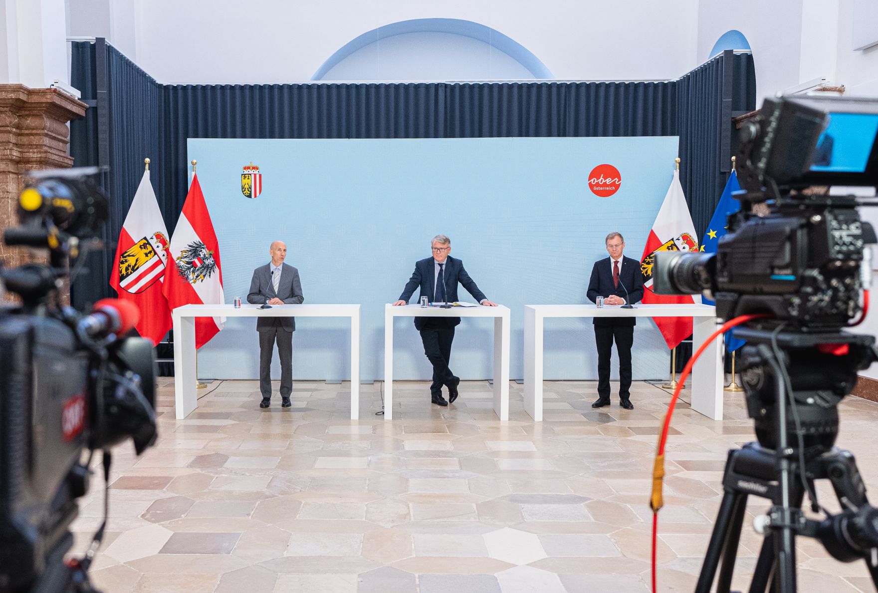 Am 16. Juli 2021 traf Bundesminister Martin Kocher (l.) im Rahmen seines Bundesl&auml;ndertags in Ober&ouml;sterreich den Landeshauptmann von Ober&ouml;sterreich Thomas Stelzer (r.) zu einem Arbeitsgespr&auml;ch. Im Bild mit EU-Kommissar Nicolas Schmit (m.) bei der gemeinsamen Pressekonferenz.
