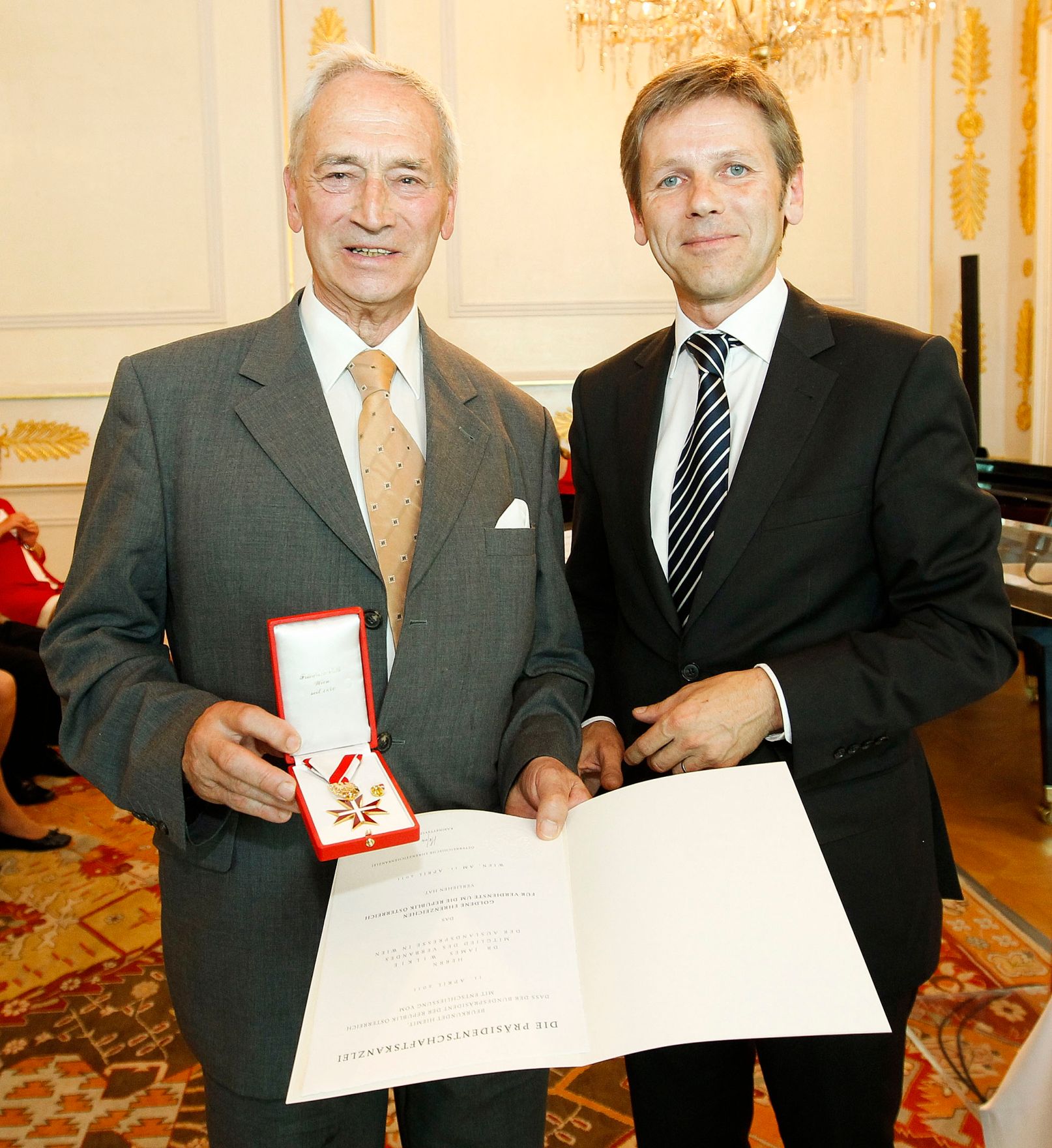 Am 22. Juni 2011 &uuml;berreichte Staatssekret&auml;r Josef Ostermayer (r.) dem &ouml;sterreichischen Journalisten James Wilkie (l.) das Goldene Ehrenzeichen f&uuml;r Verdienste um die Republik &Ouml;sterreich.