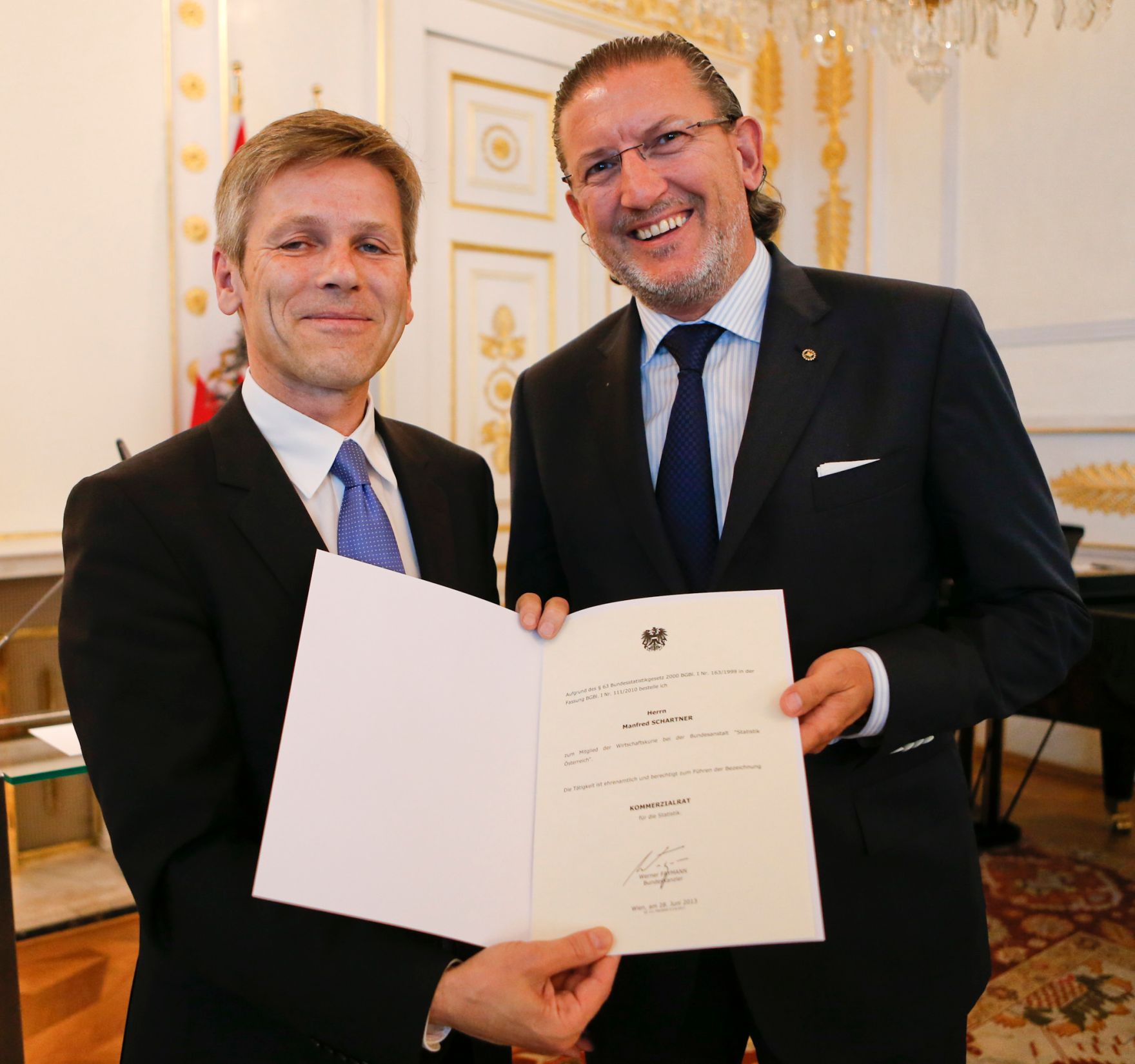 Am 28. Juni 2013 bestellte der Bundeskanzler Vertreterinnen und Vertreter der Wirtschaft zu Mitgliedern der bei der Bundesanstalt &quot;Statistik &Ouml;sterreich&quot; eingerichteten Wirtschaftskurie. Damit haben sie das Recht, die Bezeichnung &quot;Kommerzialrat f&uuml;r die Statistik&quot; zu f&uuml;hren. Im Bild Staatssekret&auml;r Josef Ostermayer (l.) bei der Dekret&uuml;berreichung an Manfred Schartner (r.).