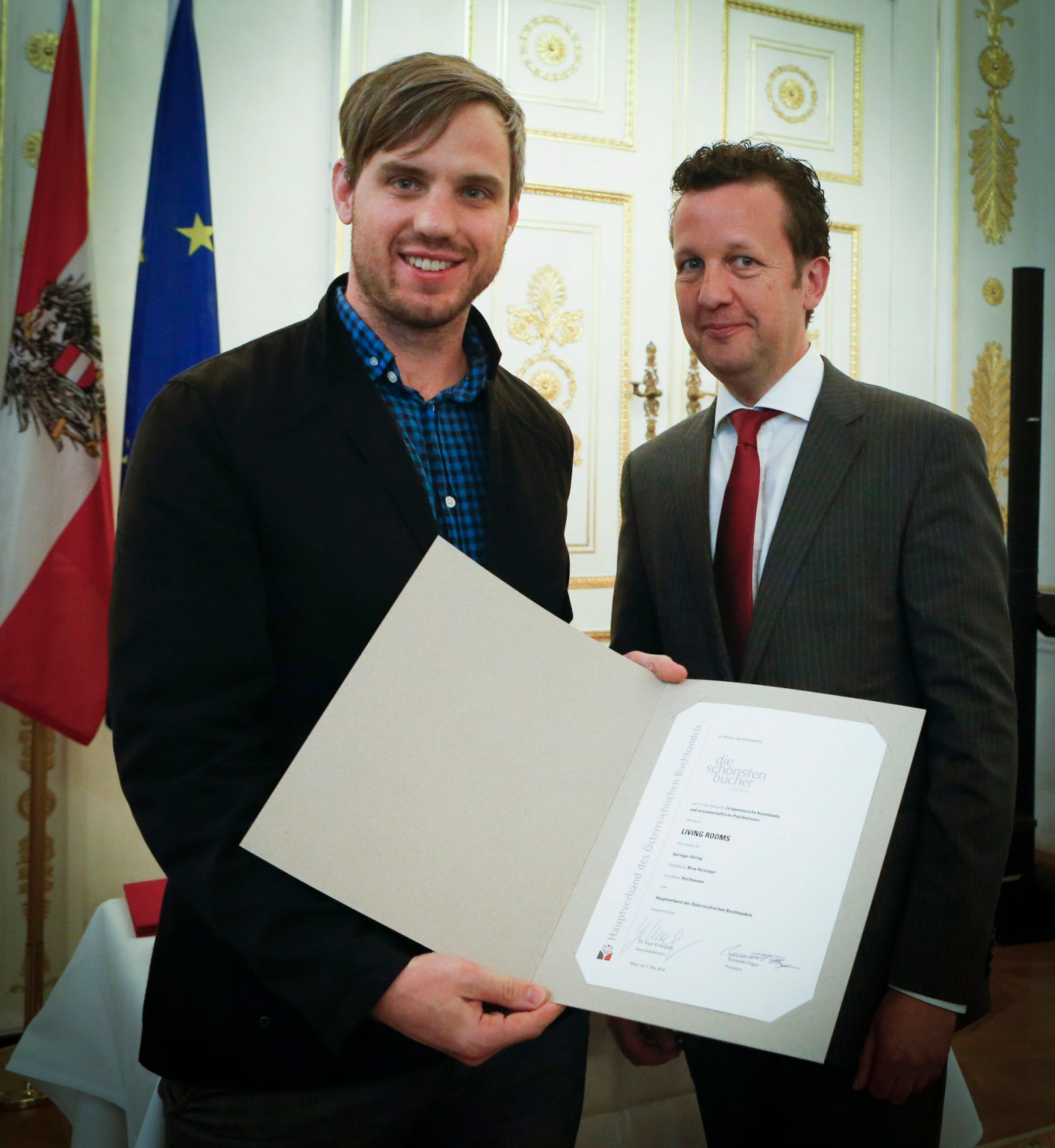 Am 7. Mai 2014 &uuml;berreichte der Pr&auml;sident des Hauptverbandes des &Ouml;sterreichischen Buchhandels Benedikt F&ouml;ger (r.) eine Ehrenurkunde an Florian Bettel (l.) im Bundeskanzleramt.