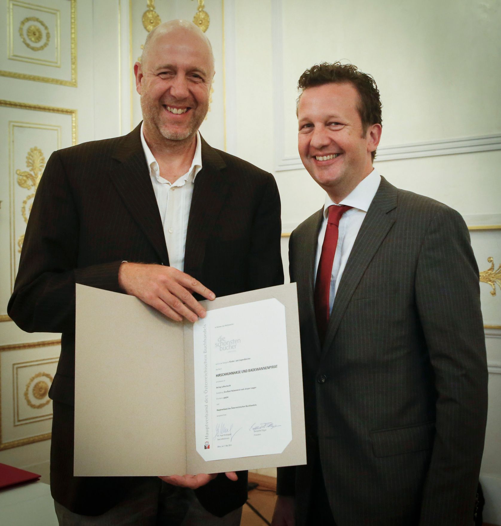 Am 7. Mai 2014 &uuml;berreichte der Pr&auml;sident des Hauptverbandes des &Ouml;sterreichischen Buchhandels Benedikt F&ouml;ger (r.) eine Ehrenurkunde an J&uuml;rgen Lagger (l.) im Bundeskanzleramt.