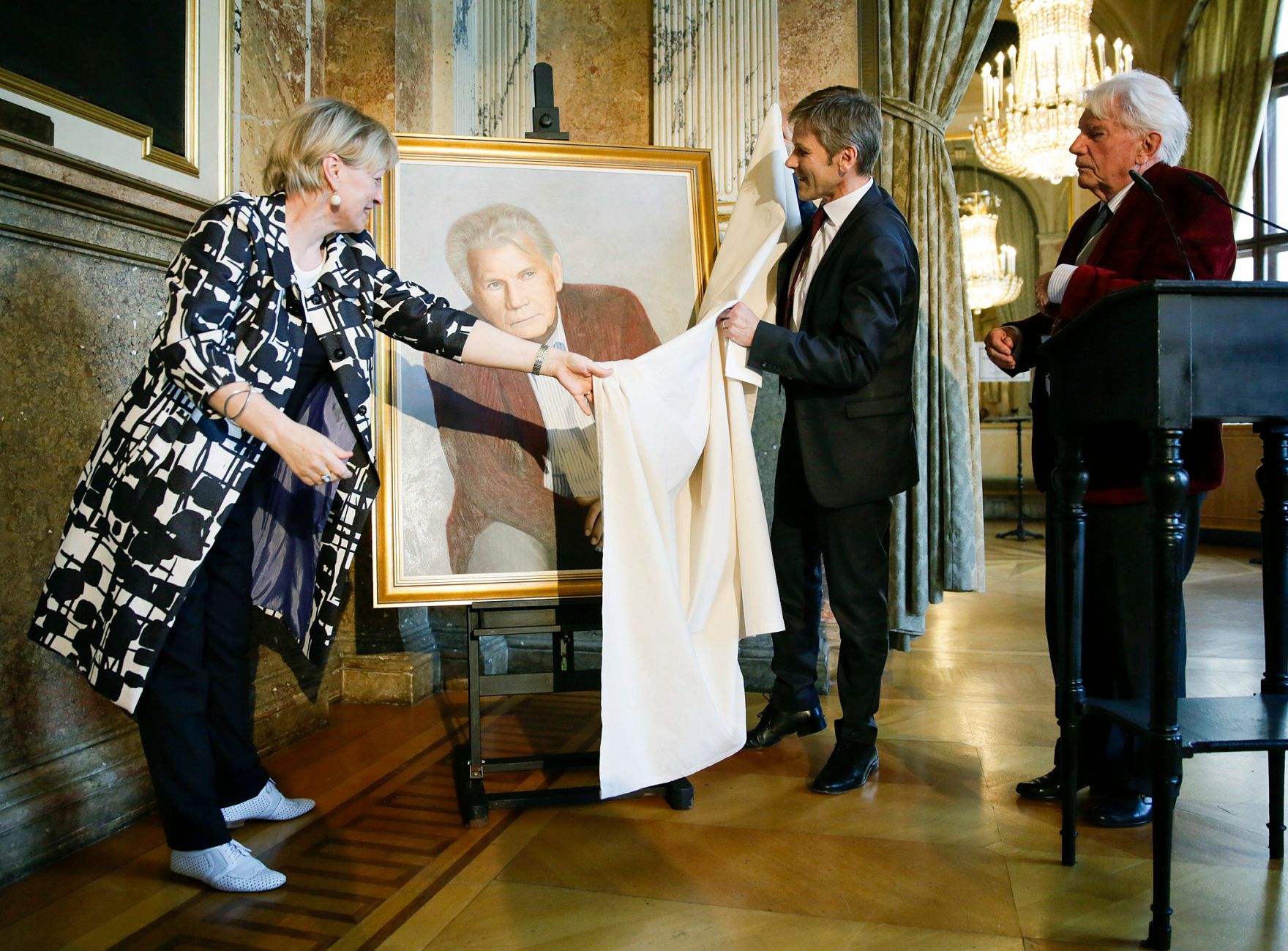 Am 4. Juni 2014 enth&uuml;llte Bundesminister Josef Ostermayer (m.) gemeinsam mit der Wiener Burgtheaterdirektorin Karin Bergmann (l.) das Portr&auml;t des Altdirektors Gerhard Klingenberg (r.). Das Bild der K&uuml;nstlerin Kristina Hadjeva h&auml;ngt nun als 200. Ehrenportr&auml;t in der Ahnengalerie des Burgtheaters.
