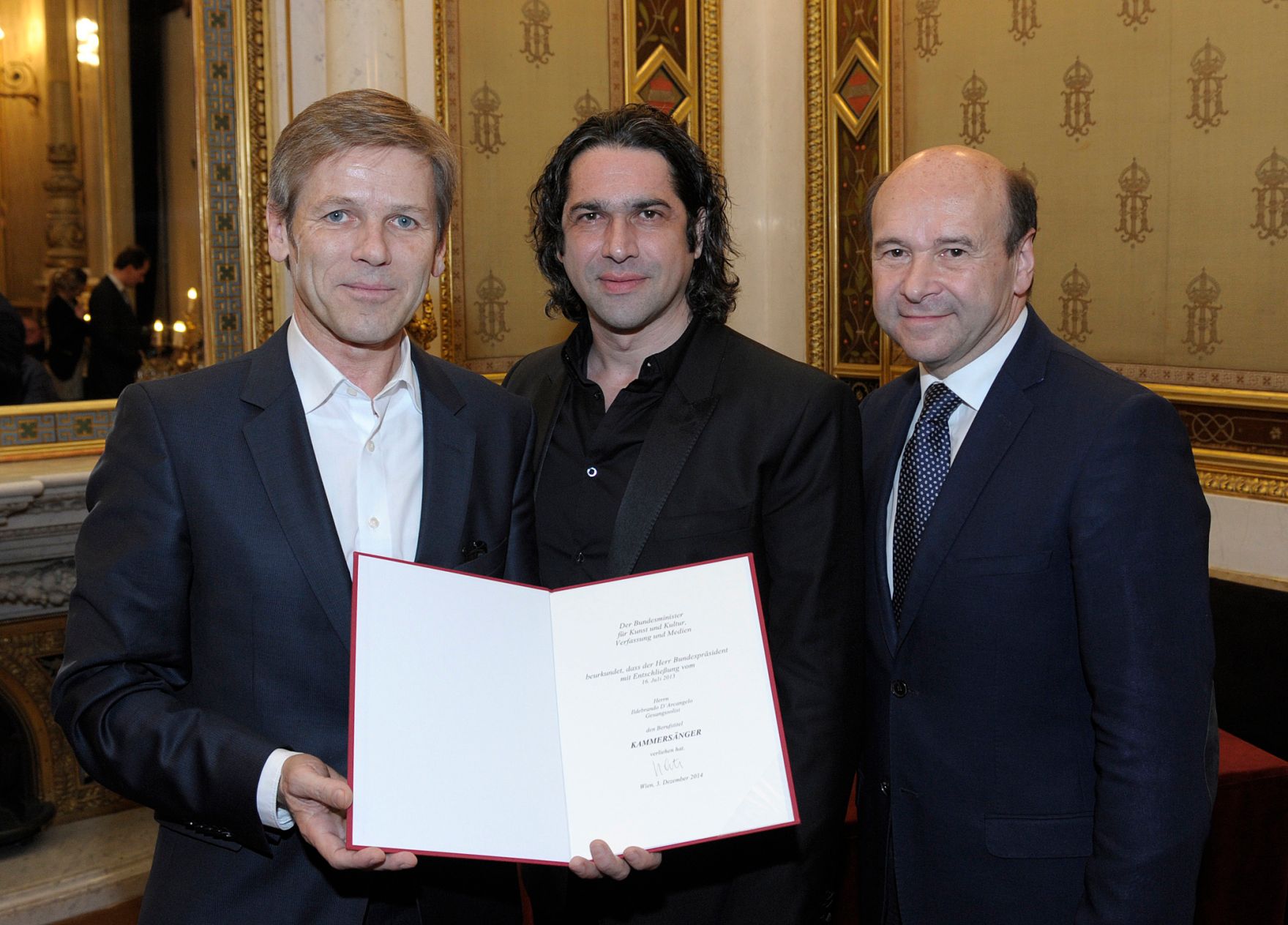 Am 3. Dezember 2014 &uuml;berreichte Kunst- und Kulturminister Josef Ostermayer (l.) die Urkunde, mit der S&auml;nger Ildebrando D&rsquo;Arcangelo (m.) der Berufstitel Kammers&auml;nger verliehen wurde. Im Bild mit Dominique Meyer (r.), Direktor der Wiener Staatsoper.