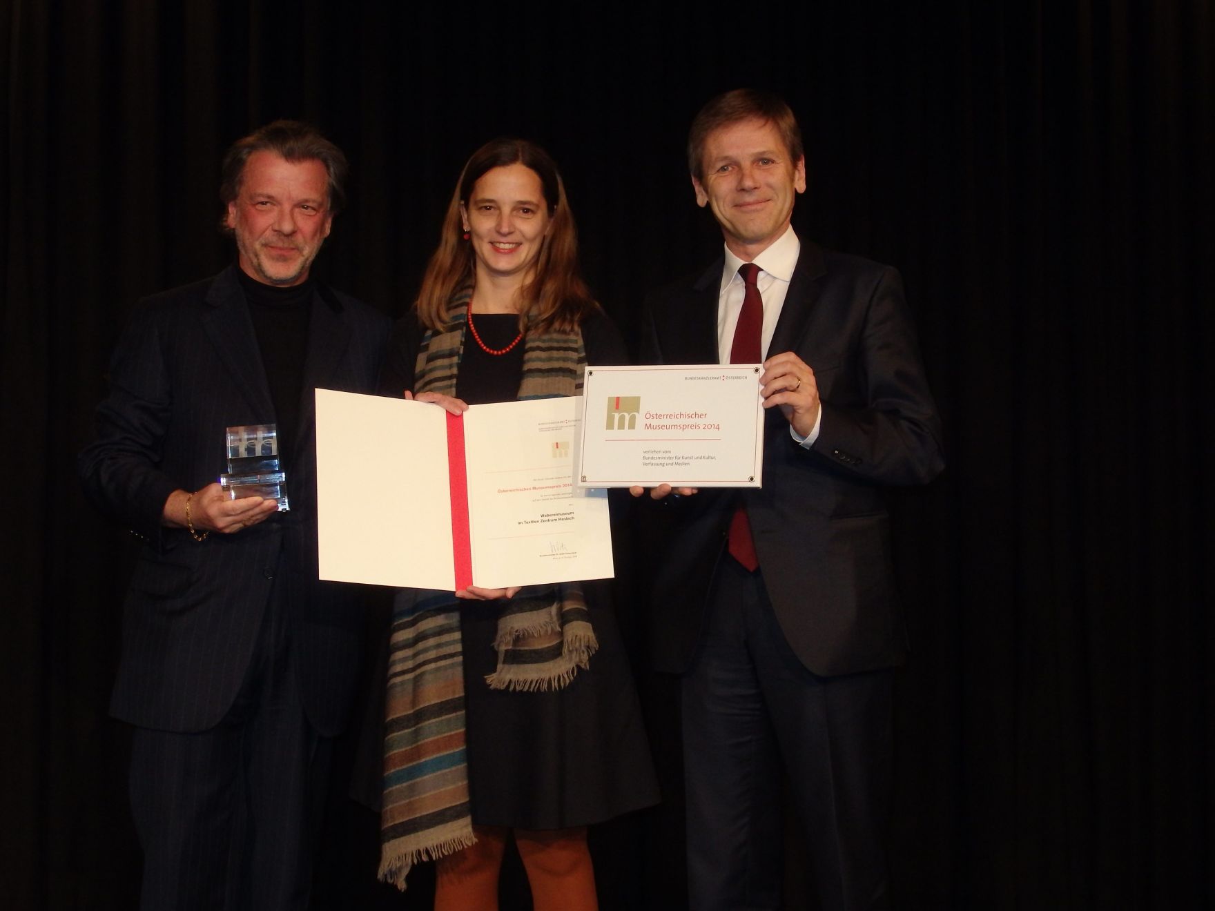 Am 3. Dezember 2014 fand die Vergabe des Museumspreises 2014 in der Marktgemeinde Haslach in Ober&ouml;sterreich statt. Im Bild Kunst- und Kulturminister Josef Ostermayer (r.) mit Sektionschef Michael P. Franz (l.) und der Gewinnerin Christine Leitner vom Weberei Museum Haslach.