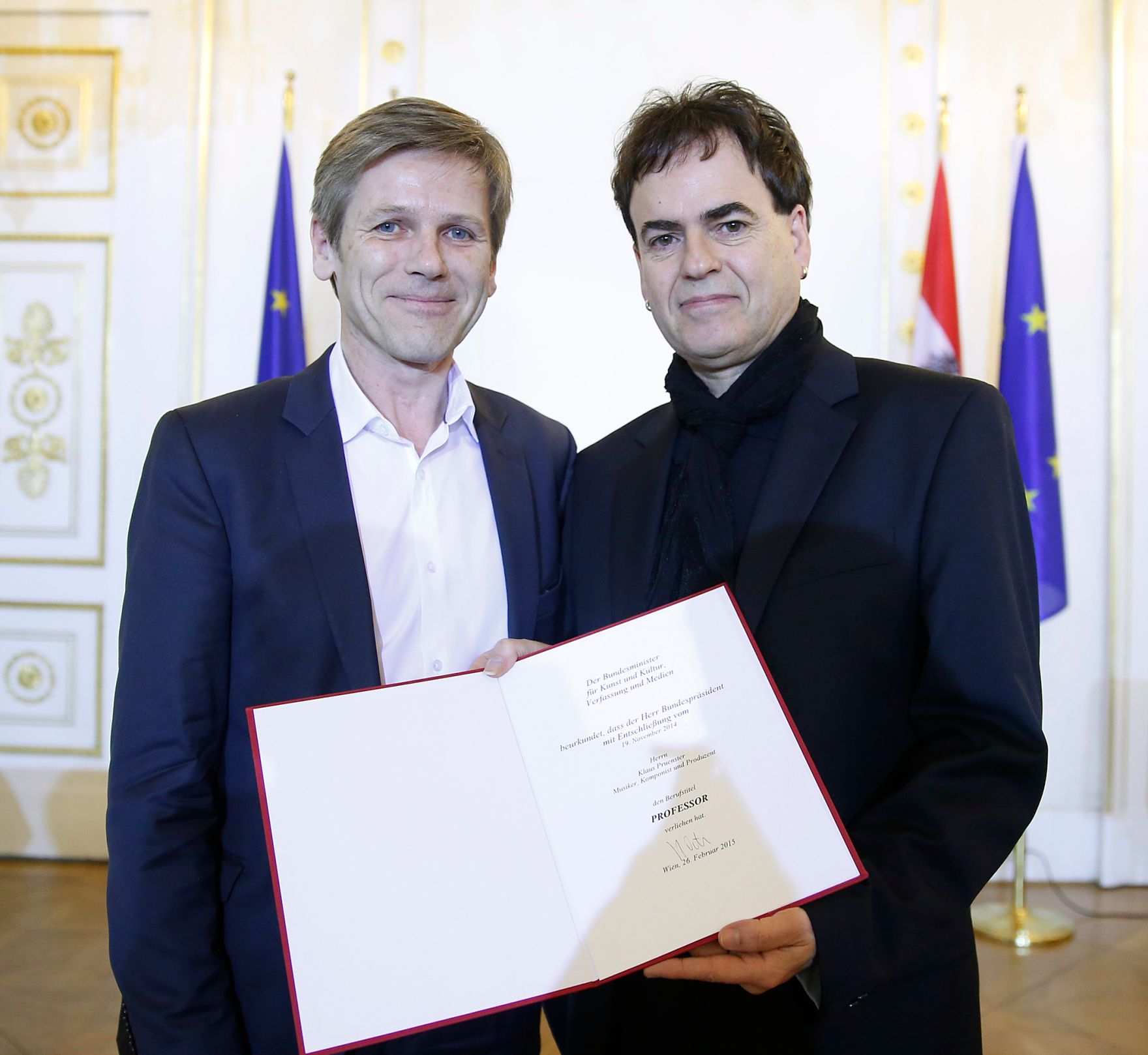 Am 26. Februar 2015 &uuml;berreichte Kunst -und Kulturminister Josef Ostermayer (l.) die Urkunde, mit der Musiker und Komponist Klaus Pruenster (r.) der Berufstitel Professor verliehen wurde.