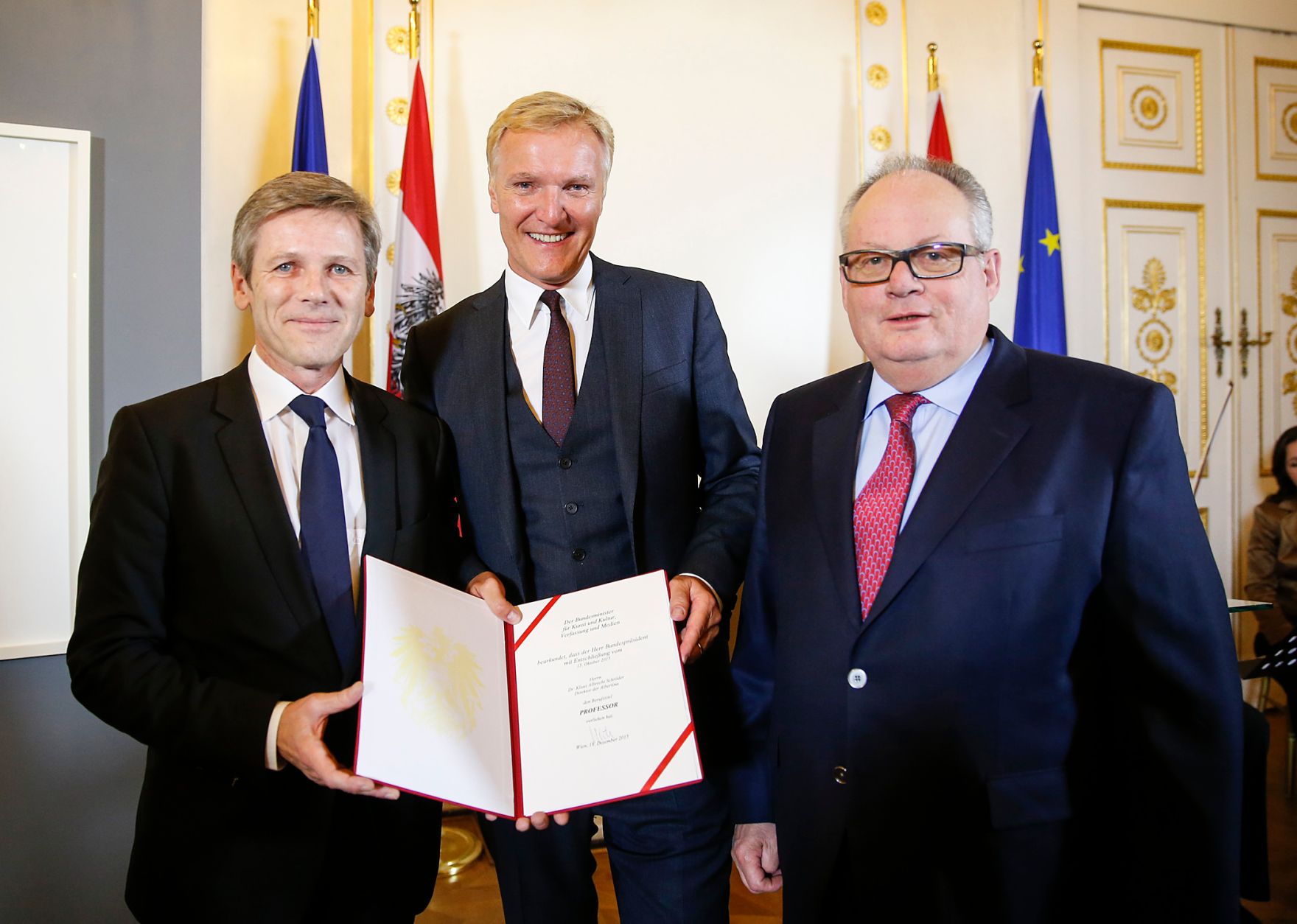 Am 18. Dezember 2015 &uuml;berreichte Kunst- und Kulturminister Josef Ostermayer (l.) die Urkunde, mit der Albertina-Direktor Klaus Albrecht Schr&ouml;der (m.) der Berufstitel Professor verliehen wurde. Im Bild mit dem Laudator Christian Konrad (r.).