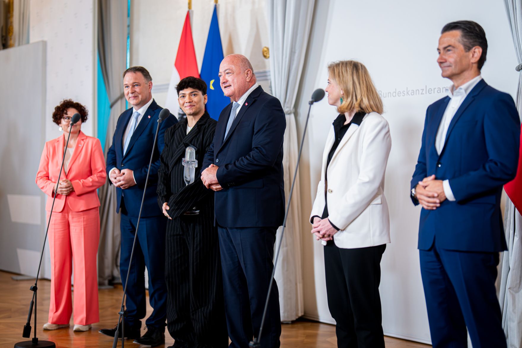 Am 19. Mai 2025 empfing Bundeskanzler Christian Stocker (4.v.l.) gemeinsam mit Vizekanzler Andreas Babler (2.v.l.), Bundesministerin Beate Meinl-Reisinger (5.v.l.) und Staatssekret&auml;rin Elisabeth Zehetner (l.) den Eurovision Song Contest-Sieger JJ (3.v.l.) im Bundeskanzleramt. Im Bild mit ORF Generaldirektor Roland Wei&szlig;mann (r.).