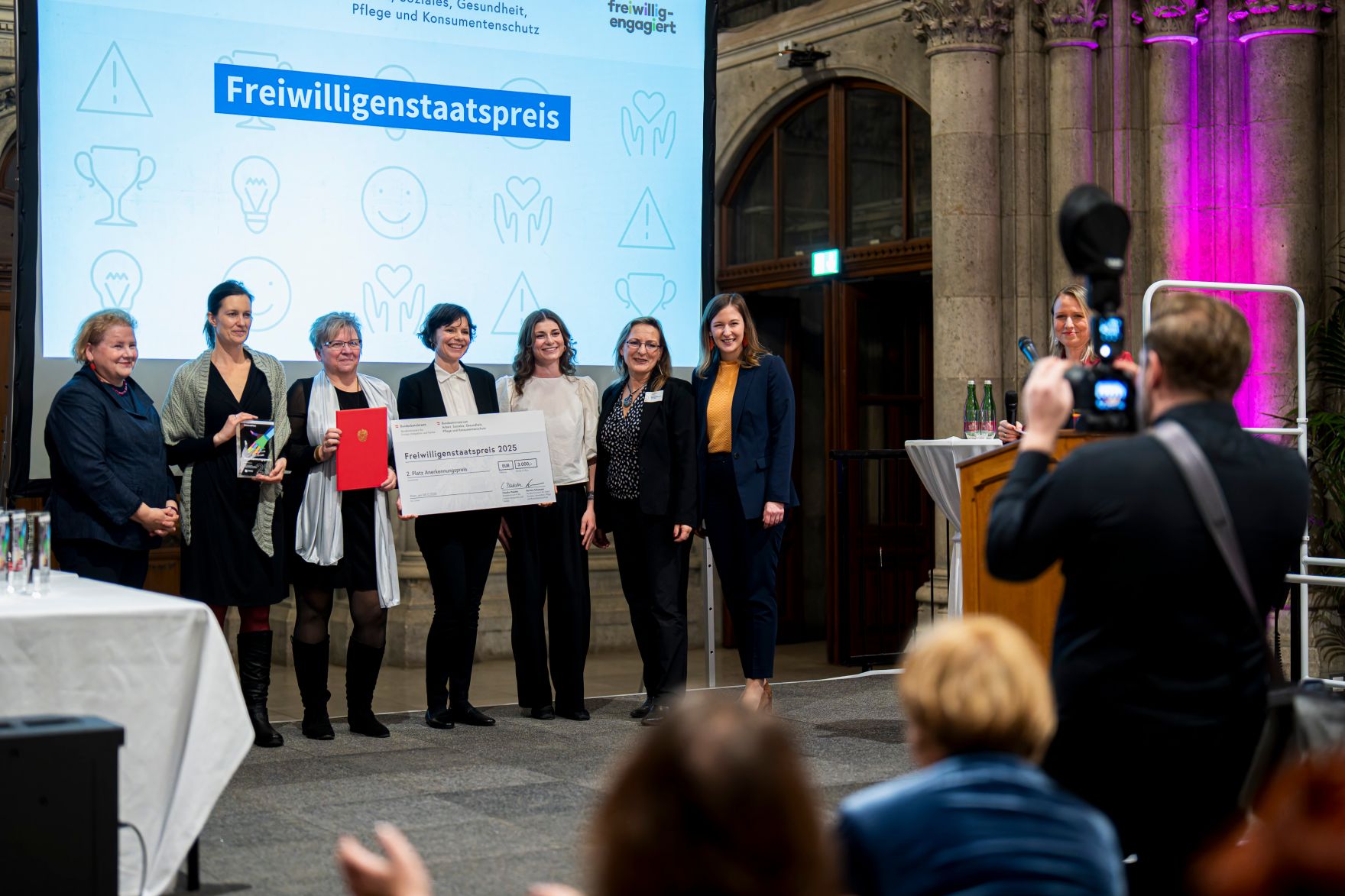 Am 4. Dezember 2025 &uuml;berreichte Bundesministerin Claudia Plakolm (7.v.l.) im Rahmen einer feierlichen Gala den 3. Staatspreis f&uuml;r freiwilliges und ehrenamtliches Engagement im Wiener Rathaus. Im Bild mit Bundesministerin Korinna Schumann (l.).