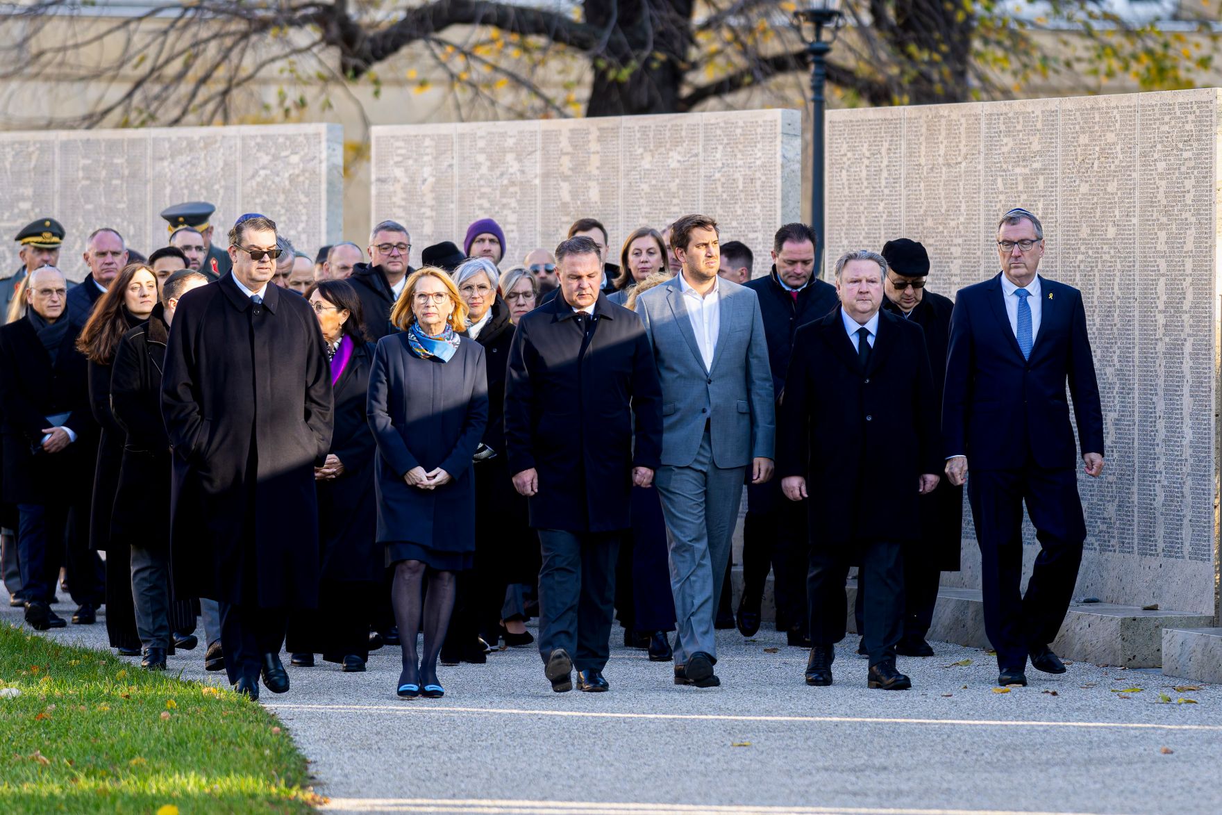 Am 7. November 2025 fand anl&auml;&szlig;lich der Novemberpogrome eine Kranzniederlegung bei der Namensmauer im Ostarrichipark statt. Im Bild Staatssekret&auml;r Alexander Pr&ouml;ll (5.v.r.), Vizekanzler Andreas Babler (6.v.r.), B&uuml;rgermeister von Wien Michael Ludwig (3.v.r.) und IKG Pr&auml;sident Oskar Deutsch (7.v.l.).
