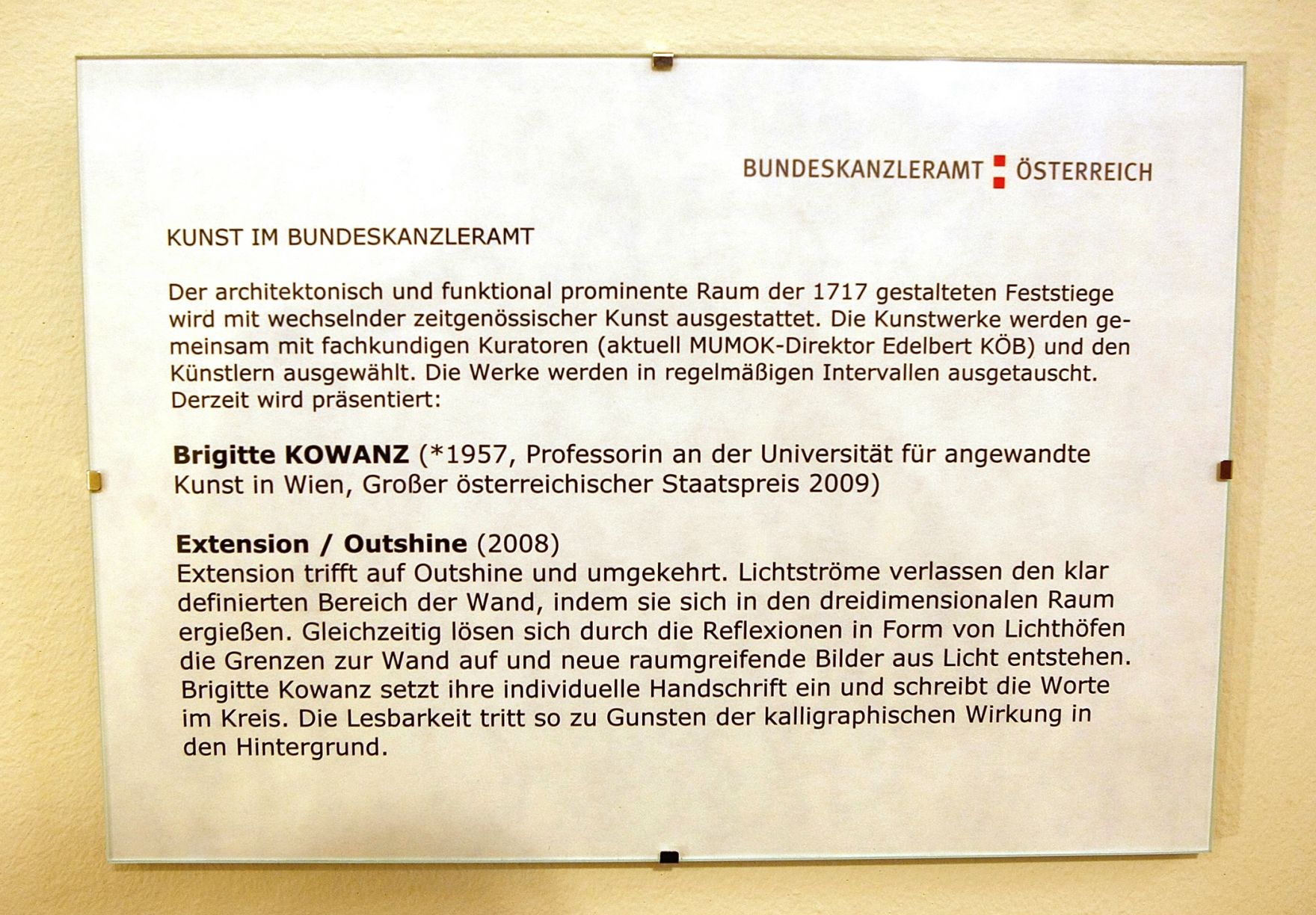 Infotafel zu dem Werk &quot;Extension / Outshine&quot; von Brigitte Kowanz ausgestellt auf der Feststiege im Bundeskanzleramt im Jahr 2010.