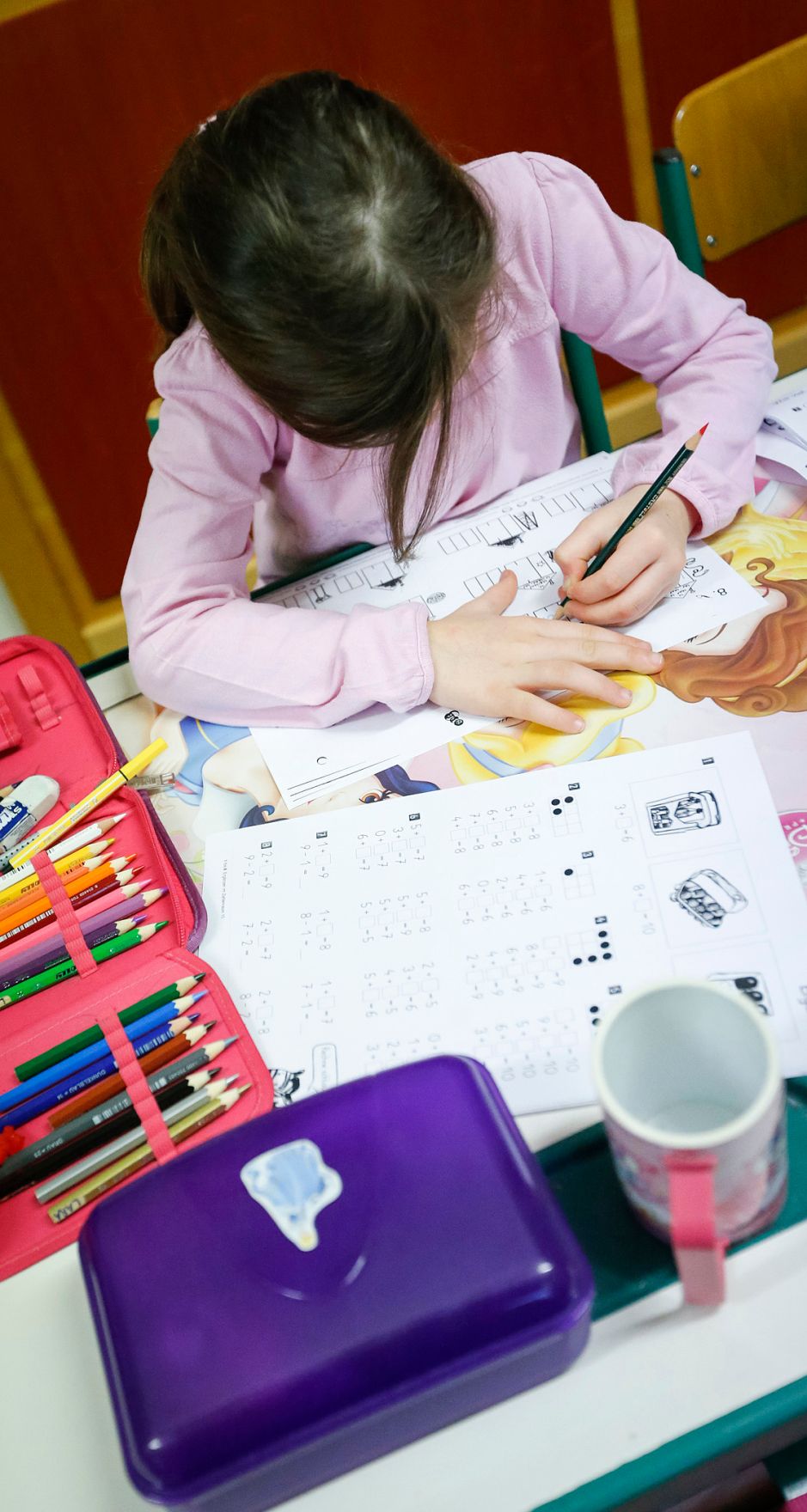 Sch&uuml;ler in einer Schule. Schlagworte: Bunt, Heft, Kind, lernen, Mensch, Stift, Tisch, Unterricht