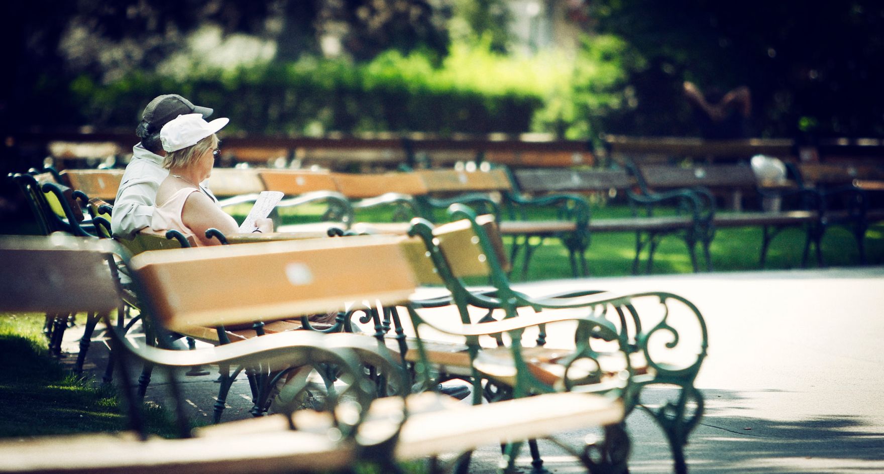 Ein P&auml;rchen sitzt auf einer Bank im Rathauspark in Wien. Schlagworte: B&auml;nke, Menschen, Natur, Paar, Park, Parkbank, Stadtlandschaft