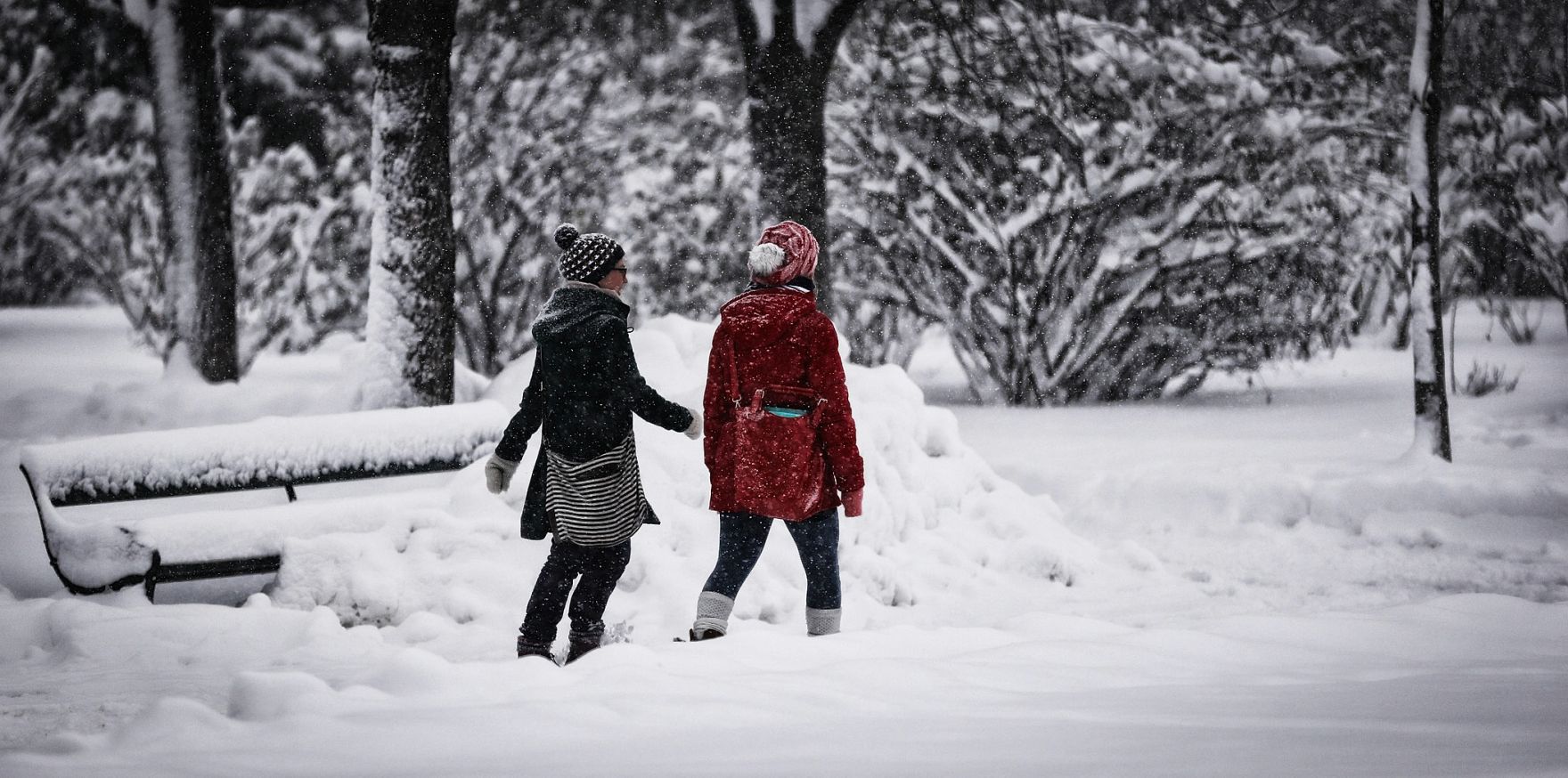 Zwei Spazierg&auml;ngerinnen im winterlichen Volksgarten. Schlagworte: Menschen, Natur, Parkbank, Schnee, Stadtlandschaft, Winter