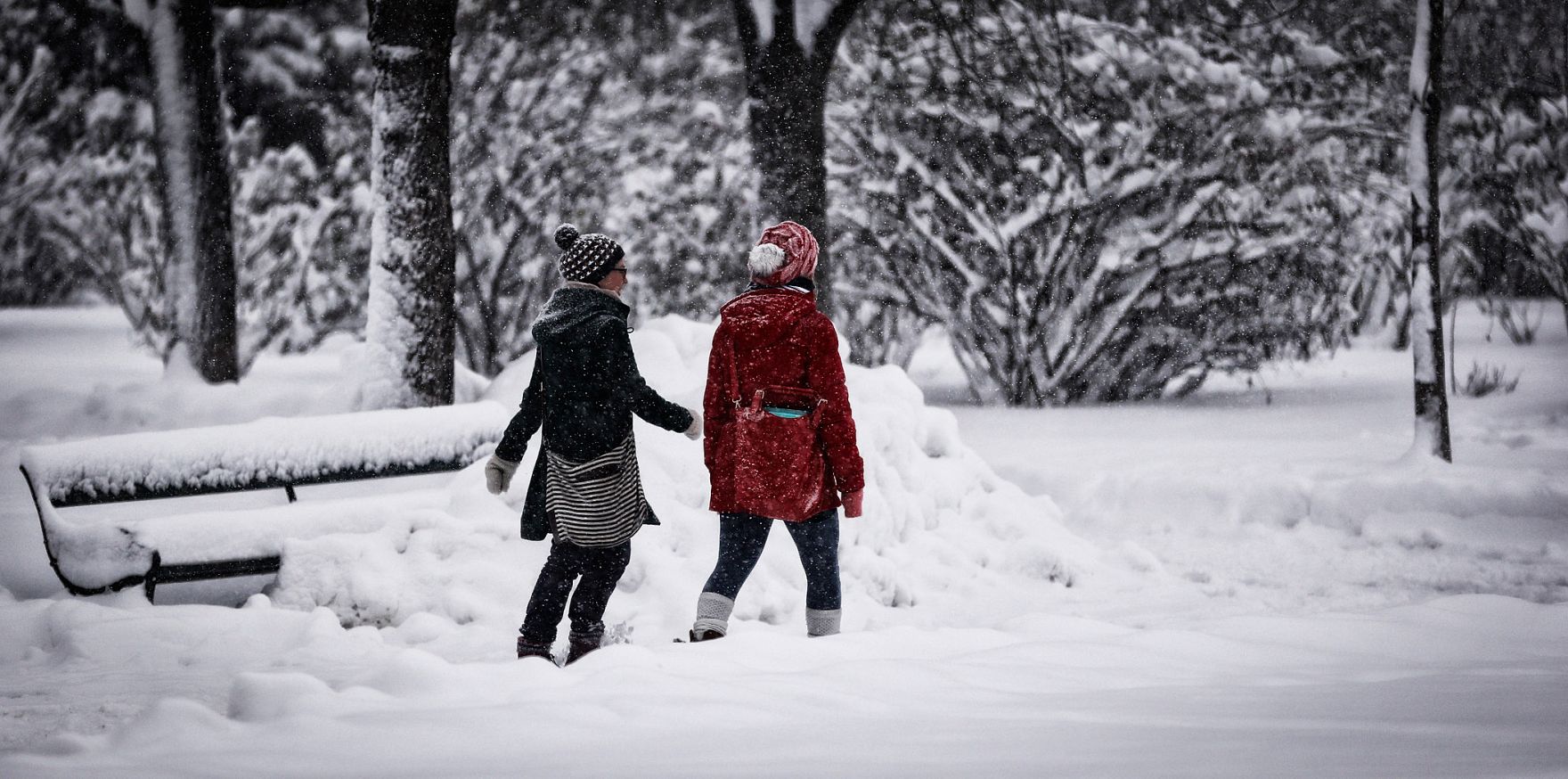 Zwei Spazierg&auml;ngerinnen im winterlichen Volksgarten. Schlagworte: Menschen, Natur, Parkbank, Schnee, Stadtlandschaft, Winter