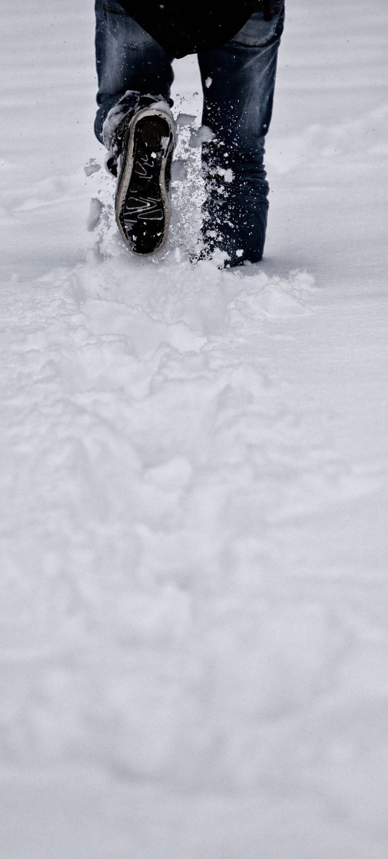 Eine winterliche Aufnahme eines Fu&szlig;g&auml;ngers. Schlagworte: F&uuml;&szlig;e, Schnee, Schuhe, Stadtlandschaft, Winter