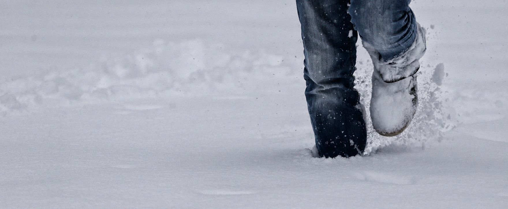 Eine winterliche Aufnahme eines Fu&szlig;g&auml;ngers. Schlagworte: F&uuml;&szlig;e, Schnee, Schuhe, Stadtlandschaft, Winter
