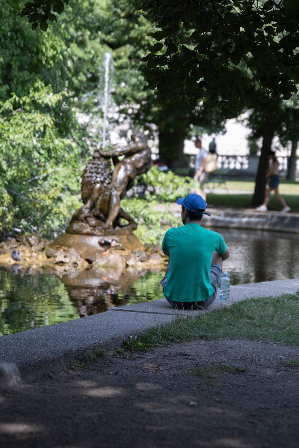 Person sitzt an einem Teich im Burggarten. Schlagw&ouml;rter: Picknick, Innenstadt, Baum, Wasserflasche, Wasser