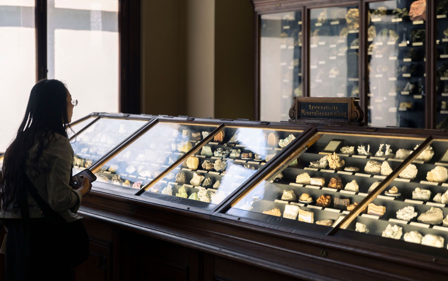 Eine Museumsbesucherin vor der Mineraliensammlung des Naturhistorischen Museums. Schlagw&ouml;rter: Mineralien, Edelsteine, Natur, Geologie