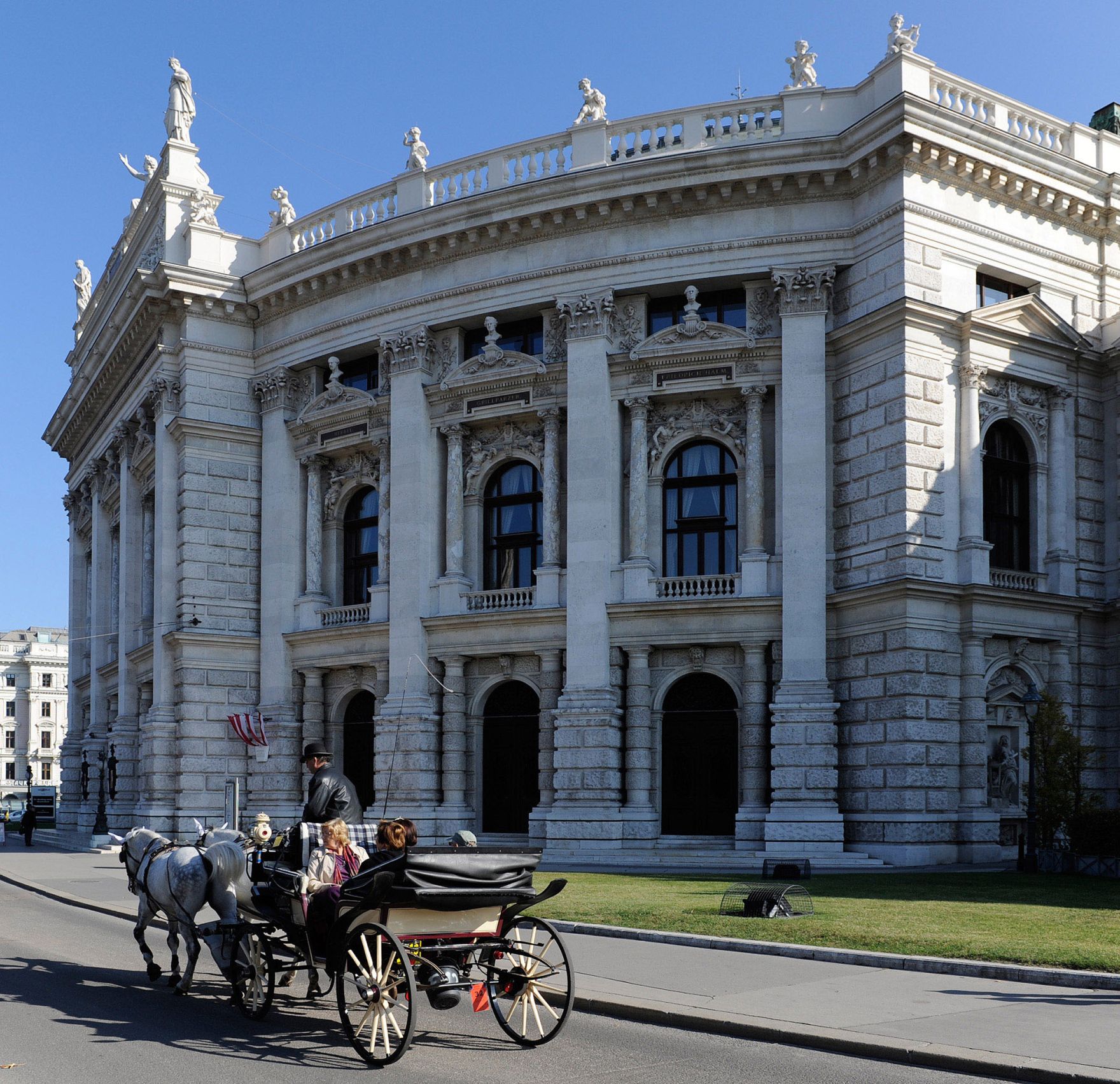 Das Wiener Burgtheater am Ring mit vorbeifahrendem Fiaker. Schlagworte: Architektur, Fahrzeug, Geb&auml;ude, Kultur, Kunst, Kutsche, Musik, Personen, Pferde, Sehensw&uuml;rdigkeit, Stadtlandschaft, Theater, Tiere
