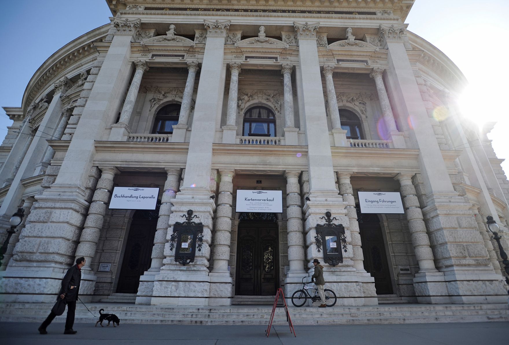 Eine Frontalaufnahme des Wiener Burgtheaters am Ring. Schlagworte: Architektur, Fahrrad, Fahrzeug, Geb&auml;ude, Hund, Hut, Kultur, Kunst, Mann, Musik, Personen, Sehensw&uuml;rdigkeit, Stadtlandschaft, Theater, Tiere