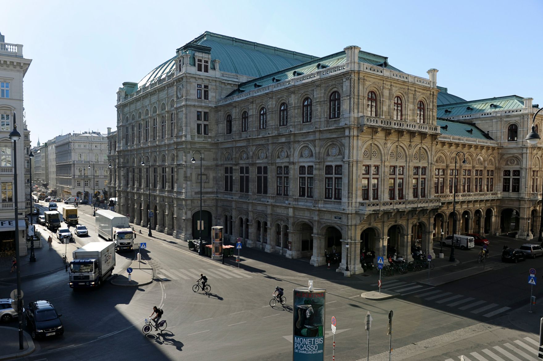 Die R&uuml;ckseite der Wiener Staatsoper mit Verkehrsszene im Vordergrund. Schlagworte: Architektur, Autos, Fahradfahrer, Fahrzeuge, Verkehr, Geb&auml;ude, Sehensw&uuml;rdigkeit, Stadtlandschaft, Stra&szlig;e