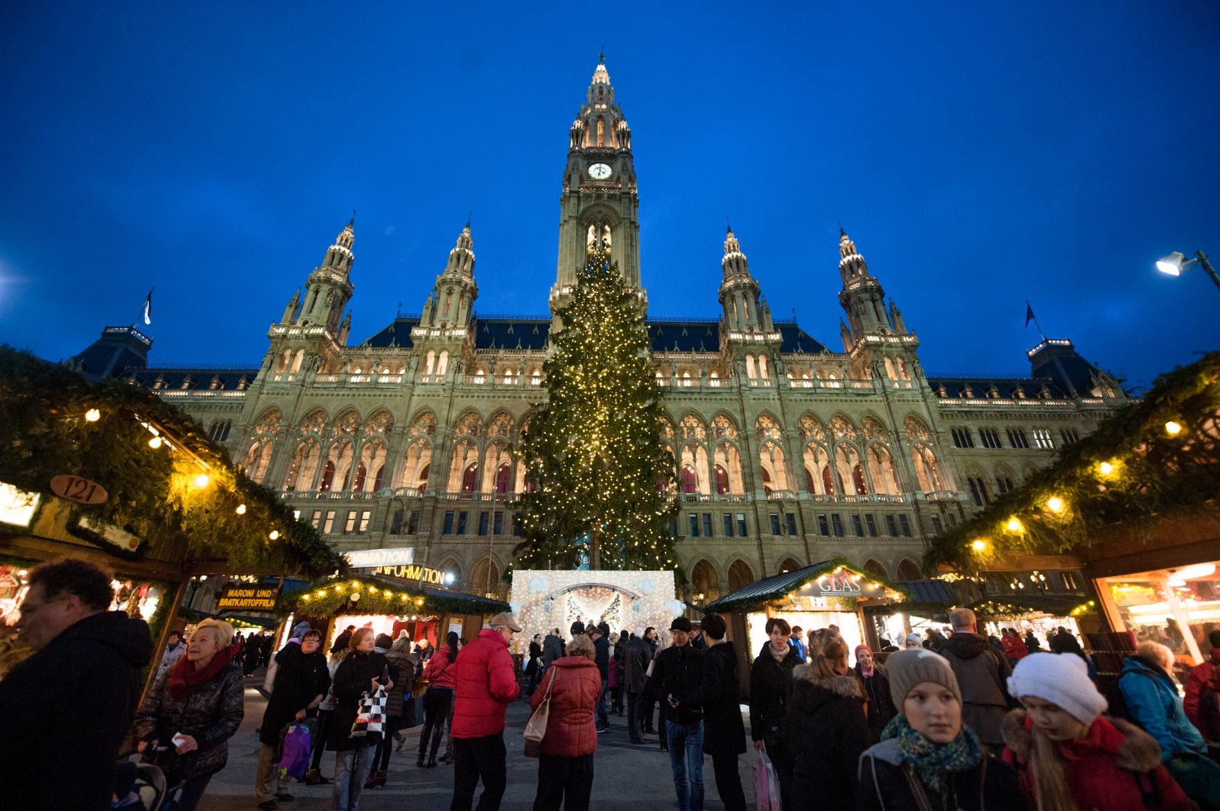 Der Christkindlmarkt am Rathausplatz bei Nacht. Schlagworte: Abend, Beleuchtung, Christbaum, Kugeln, Marktstand, Menschen, Rathaus, Sehensw&uuml;rdigkeit, Stadtlandschaften, Weihnachten, Weihnachtsbaum
