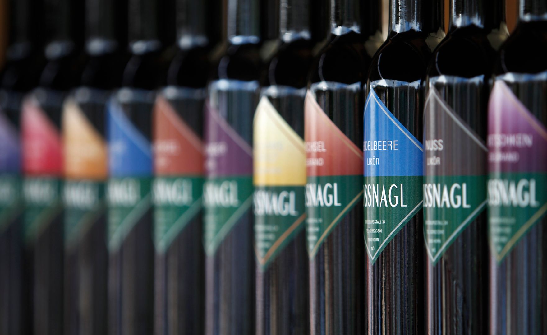 Eine Reihe von Lik&ouml;rflaschen mit bunten Etiketten. Schlagworte: Alkohol, Etiketten, Gastronomie, Glas, Trinken