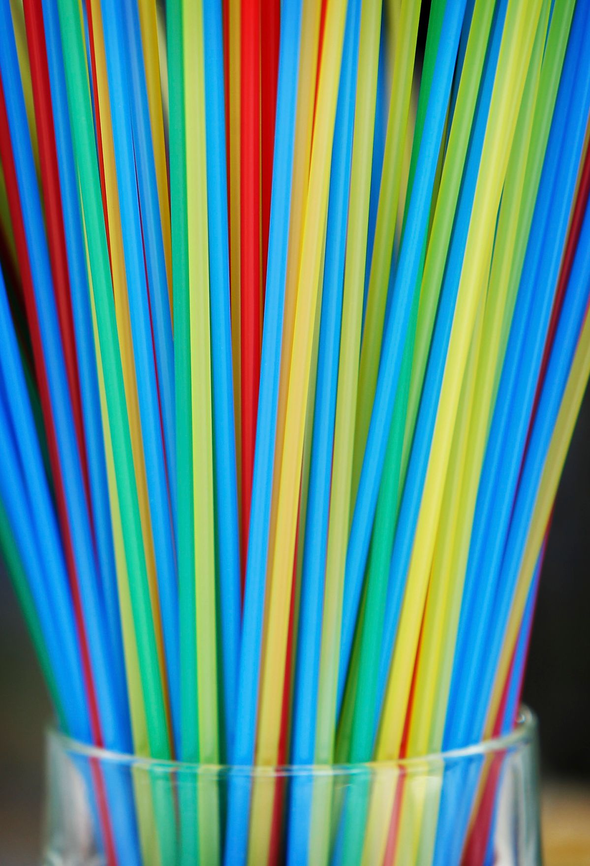 Viele bunte Strohhalme in einem Glas. Schlagworte: Gastronomie, Glas, Trinken