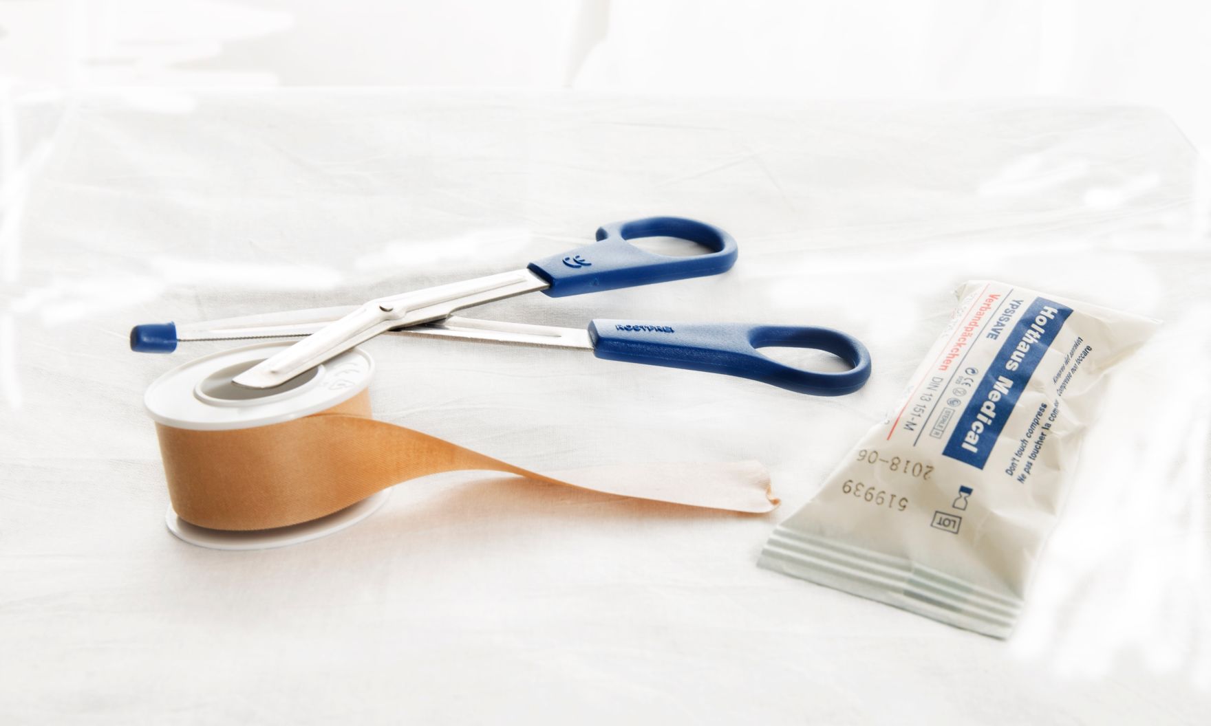 Verbandszeug Schlagworte: Gesundheit, Erste Hilfe, Fixierpflaster, Medizin, Mullbinde, Schere