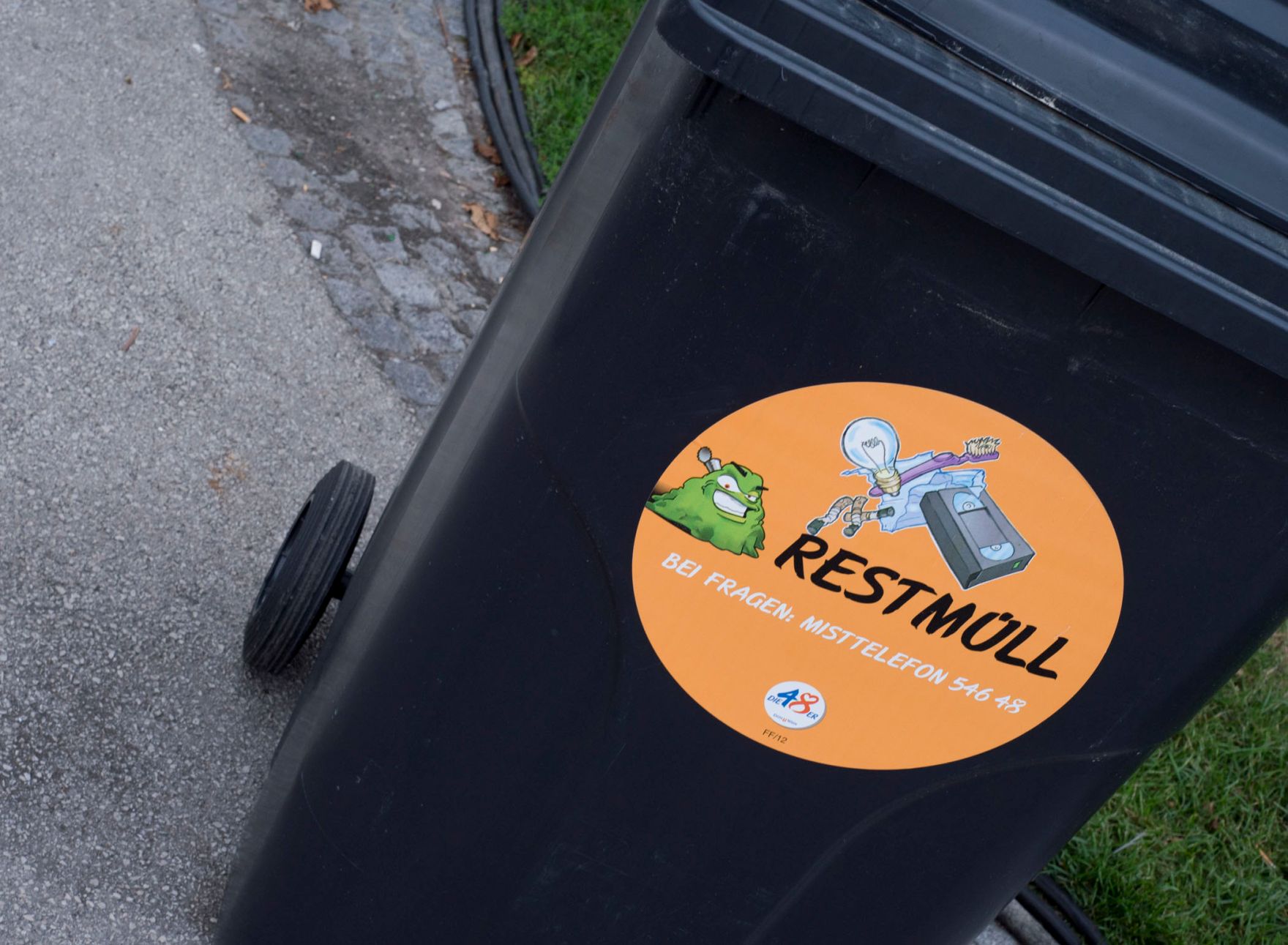 Abfallcontainer f&uuml;r Restm&uuml;ll mit dem Hinweis auf das Misttelefon der MA 48. Schlagworte: Mist, Mistk&uuml;bel, M&uuml;ll, Stadtlandschaft