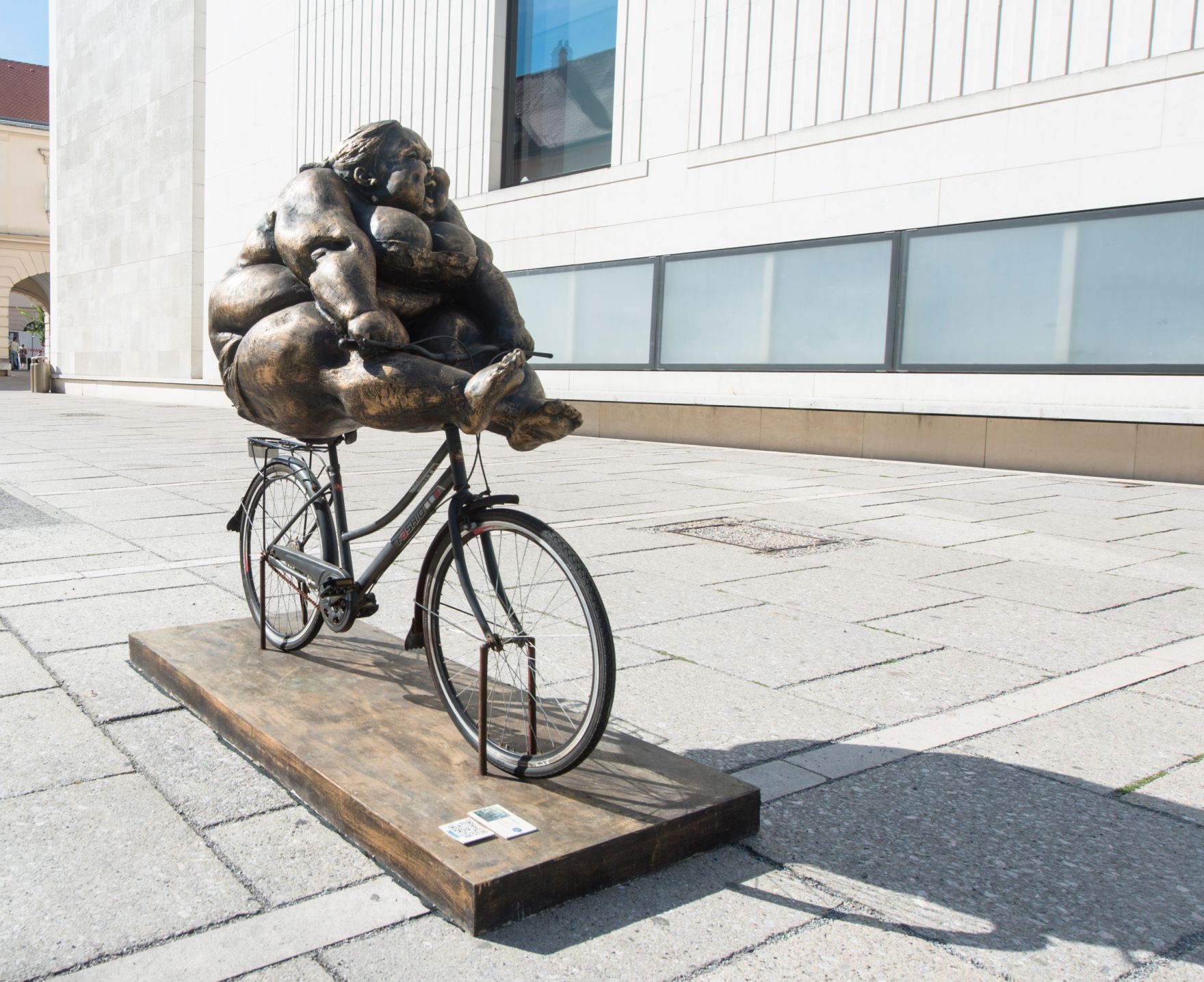 Skulpturen des chinesischen K&uuml;nstlers Xu Hongfei aus der Chubby Women Sammlung im Haupthof des Museumsquartiers. Schlagworte: Ausstellung, Fahrrad, Frau, Geb&auml;ude, Kunst, K&uuml;nstler, MQ, Museum, Skulptur