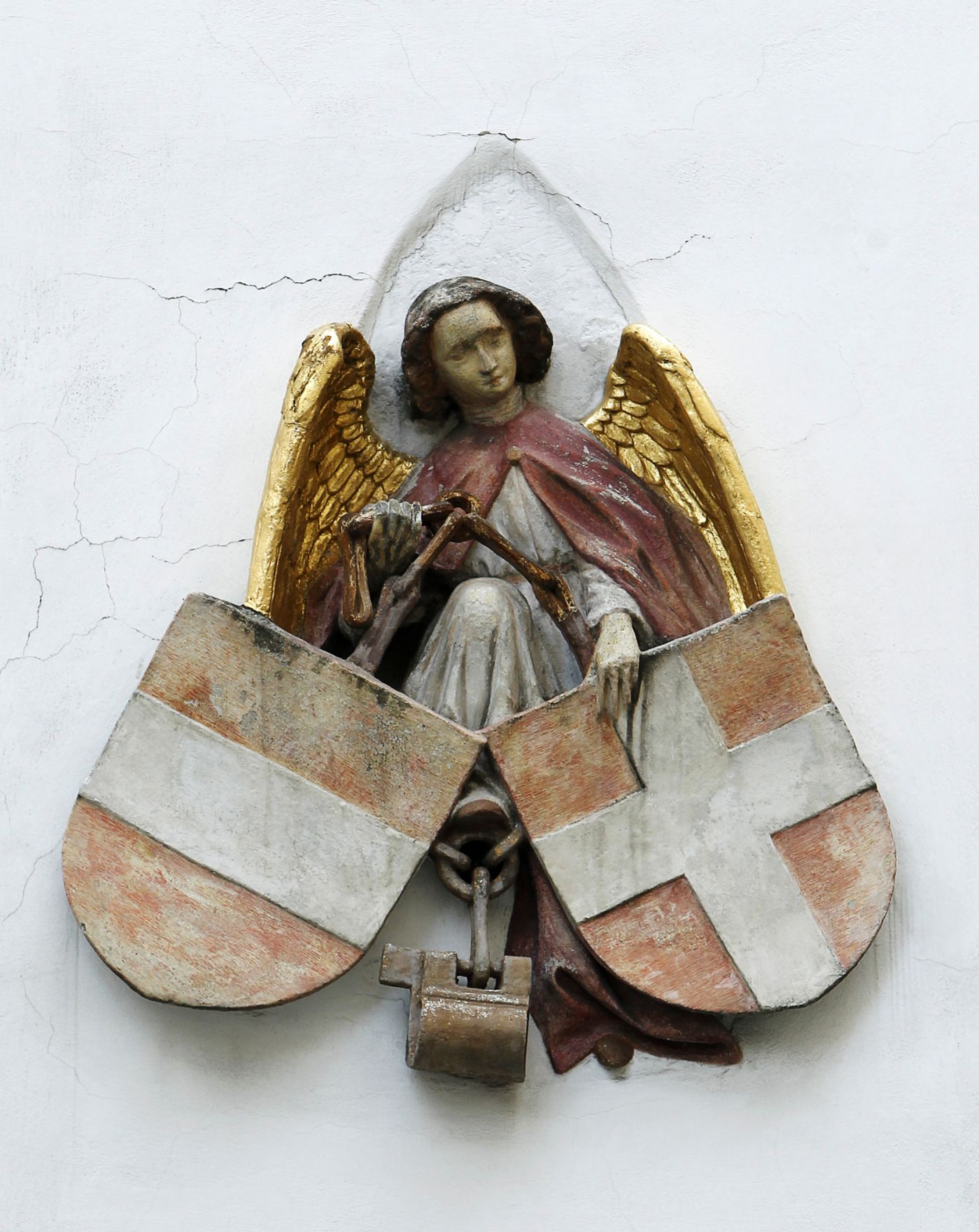 Engelsfigur mit goldenen Fl&uuml;geln und den Wappen f&uuml;r &Ouml;sterreich und Wien an einer Hauswand im ersten Bezirk. Schlagworte: Denkmal, heilig, Stadtlandschaft, Statue