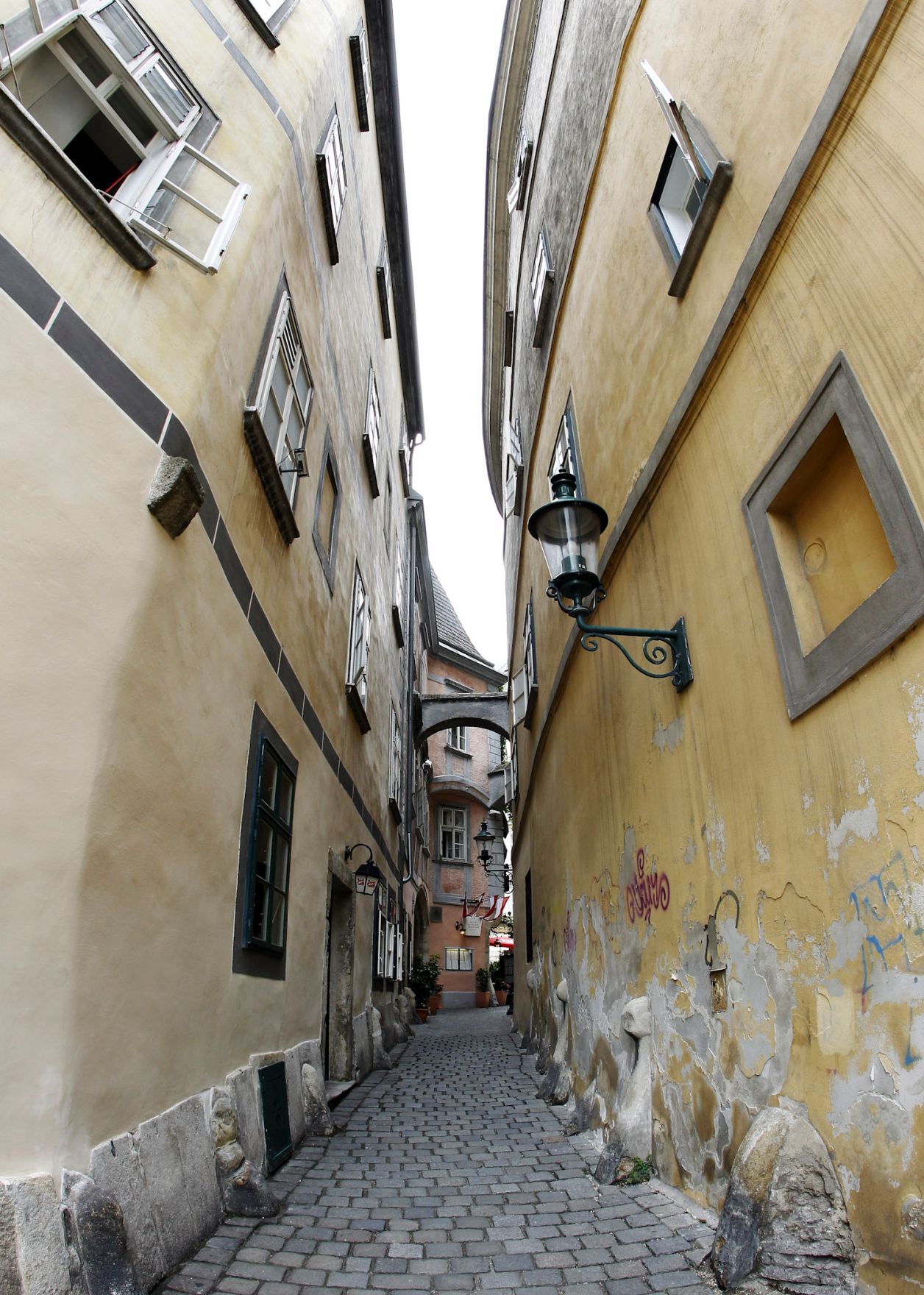 Architekturaufnahme von einer alten Gasse im ersten Bezirk. Schlagworte: Geb&auml;ude, Laterne, Pflastersteine, Stadtlandschaft