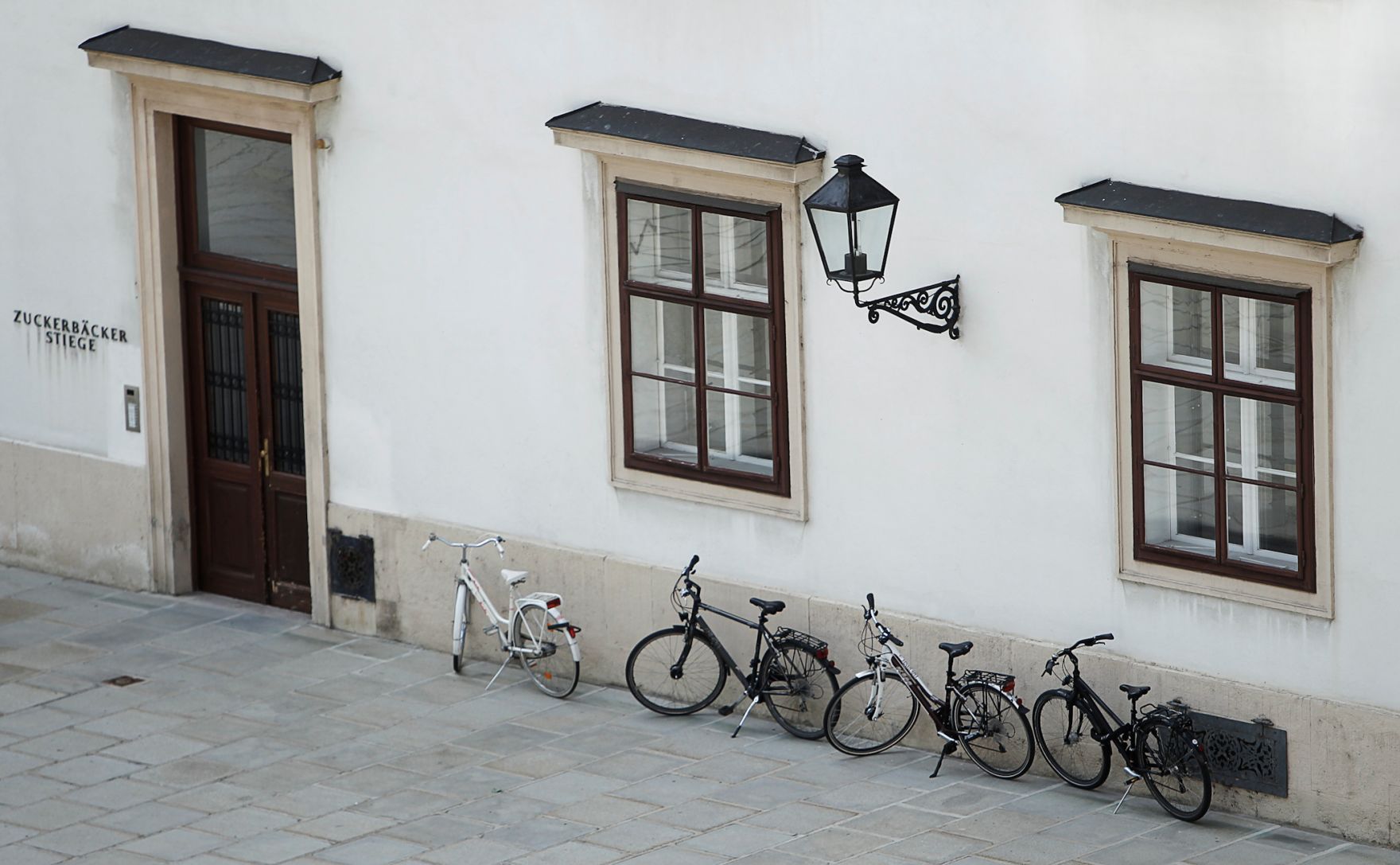 Die Zuckerb&auml;ckerstiege der Wiener Hofburg, mit davor abgestellten Fahrr&auml;dern. Schlagworte: Fahrrad, Fahrzeuge, Fassade, Fenster, Geb&auml;ude, Stadtlandschaft, Statuen, Tor, T&uuml;r