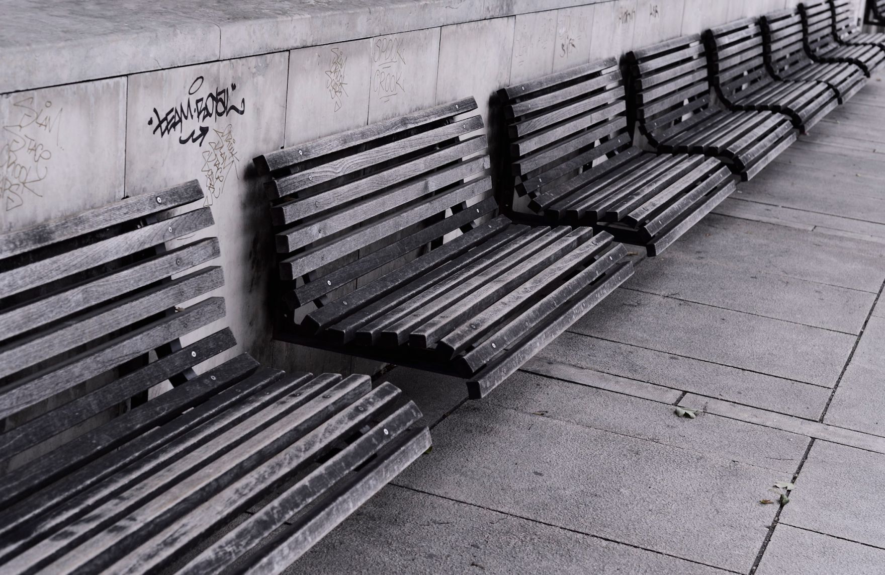 Mehrere Sitzb&auml;nke im MuseumsQuartier. Schlagworte: Bank, Fassade, Fenster, Graffiti, Holz, Mauer, Parkbank, Stadtlandschaft