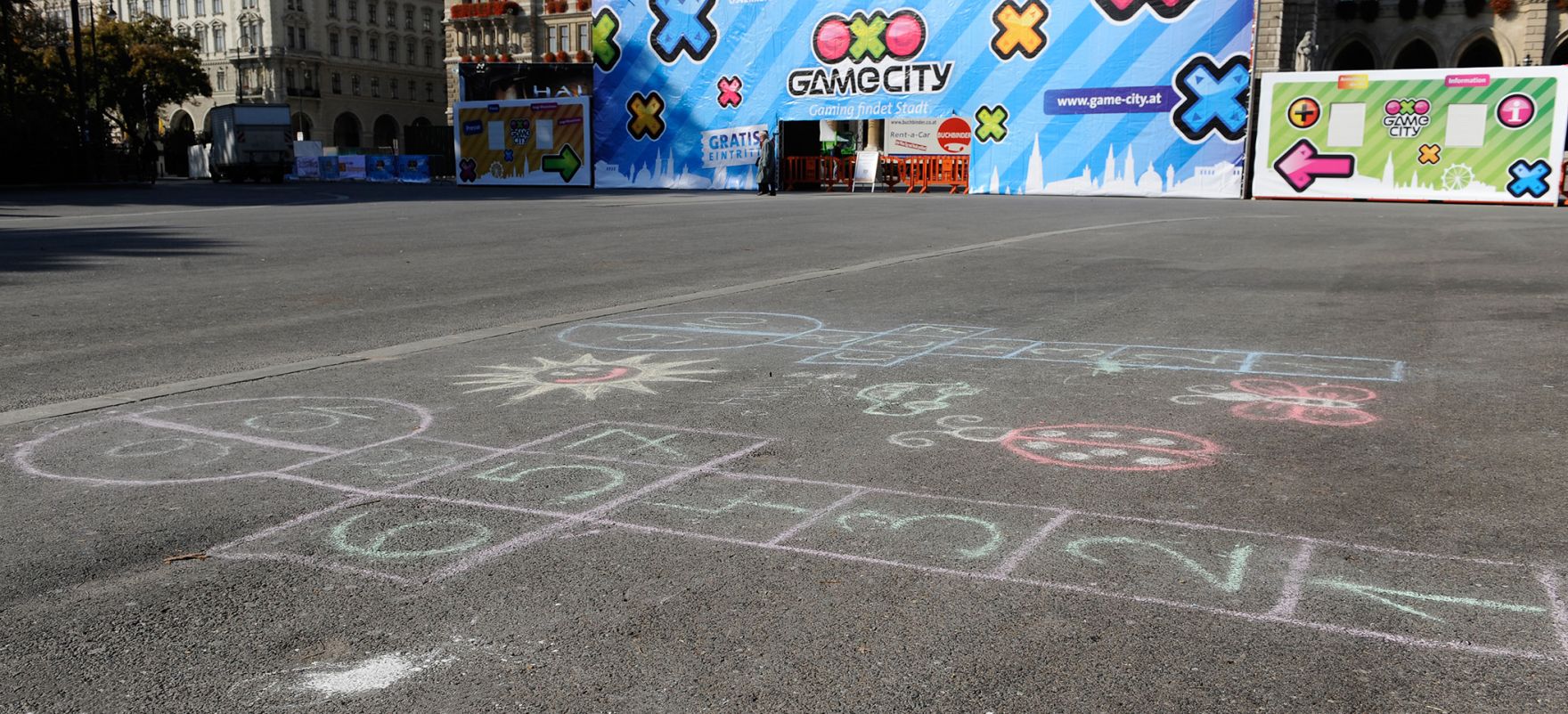 Kreidemalerei am Rathausplatz, im Hintergrund der Eingang zur 'Game City'. Schlagworte: Kinderspiel, Spiele, Stadtlandschaft, Tempelh&uuml;pfen