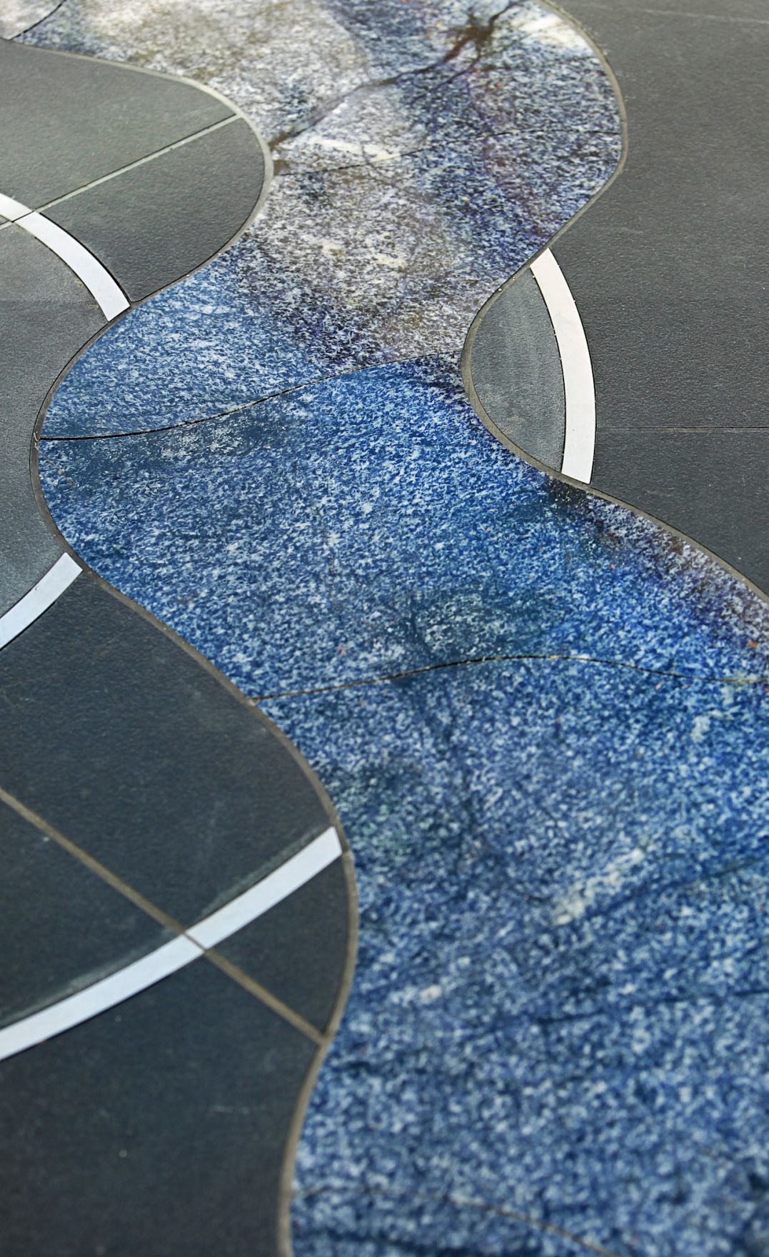 Detailaufnahme eines Kunstwerks am Minoritenplatz. Schlagworte: Kunst, Spiele, Stadtlandschaft, Steintafel, Wasser, Welle