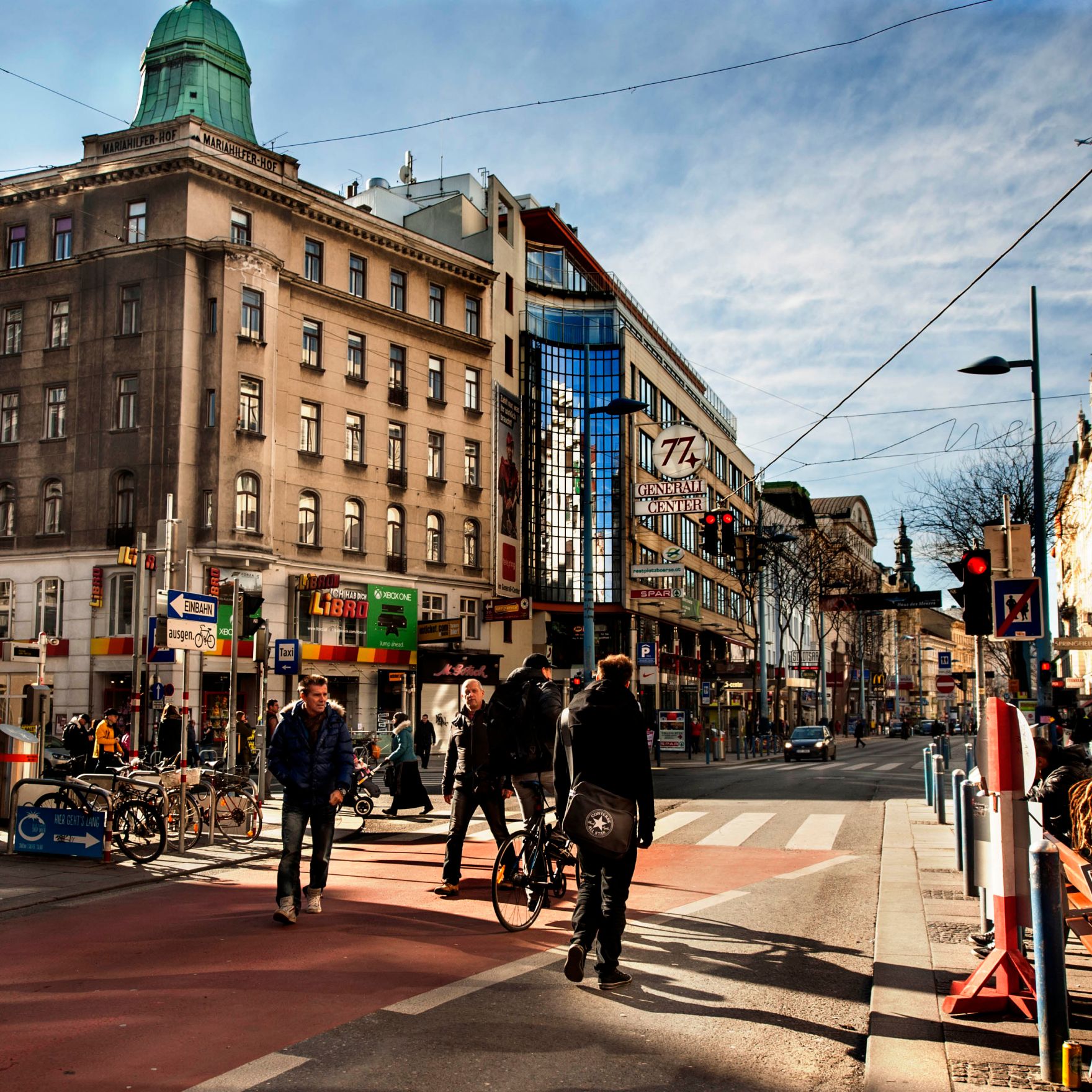 Verkehr auf der Mariahilferstra&szlig;e. Schlagworte: Auto, Ampel, Himmel, Menschen, Sonne, Stadtlandschaften